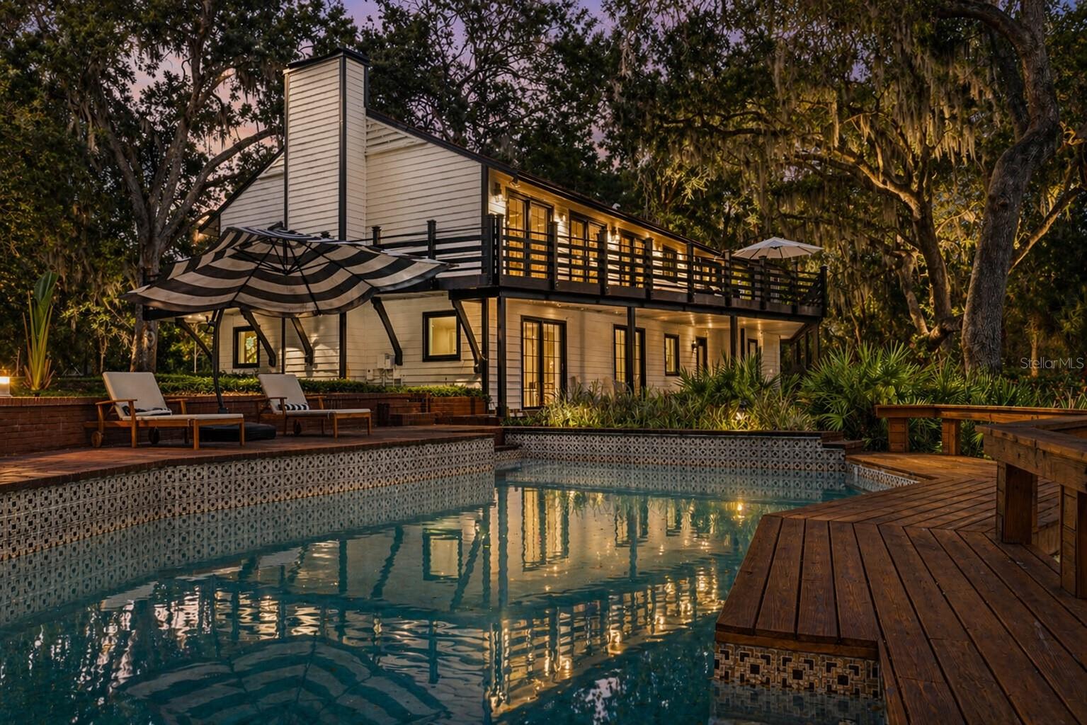 Tucked away on a quiet, private cul-de-sac, 900 Oak Hollow offers a rare lifestyle balance—resort living, on over two acres of lush, tree-lined grounds, just minutes from Water Street and Downtown Tampa, yet completely removed in feel. The property delivers a level of privacy, scale, and tranquility that’s increasingly rare this close to the city.

Fully reimagined through a comprehensive 2024–2025 renovation, the estate blends modern upgrades with timeless design. A striking exterior creates a clean, architectural presence, while entry is framed by a custom, heavy-duty iron door and tasteful white oak flooring, setting the tone for the level of craftsmanship and detail carried throughout. The main residence offers 3 bedrooms and 4 spa-style bathrooms, complemented by newer core systems and infrastructure, including plumbing, electrical, HVAC, and roof, delivering both elevated design and long-term peace of mind.

Designed to live as beautifully as it entertains, expansive open living spaces connect to a chef’s kitchen outfitted with new Thermador appliances, then flow seamlessly outdoors to a resort-style pool and deck overlooking the pond, where ducks glide by and the landscape becomes part of the experience. As the sun sets, over 60 exterior solar-powered lights create a warm, ambient glow across the grounds—transforming the property into a true evening retreat.

A fully renovated and furnished 3-bedroom, 1-bath guest residence adds exceptional flexibility—ideal for hosting, extended stays, or immediate income potential. Throughout the home, generous storage and well-proportioned closets enhance everyday livability without compromising design.

Ample parking, a private setting, and seamless indoor-outdoor living position the property as a true entertainer’s retreat or a private estate sanctuary designed for both gathering and everyday living—with effortless access to Tampa’s most dynamic lifestyle destinations and major thoroughfares.

A rare offering where privacy, presence, and proximity converge.