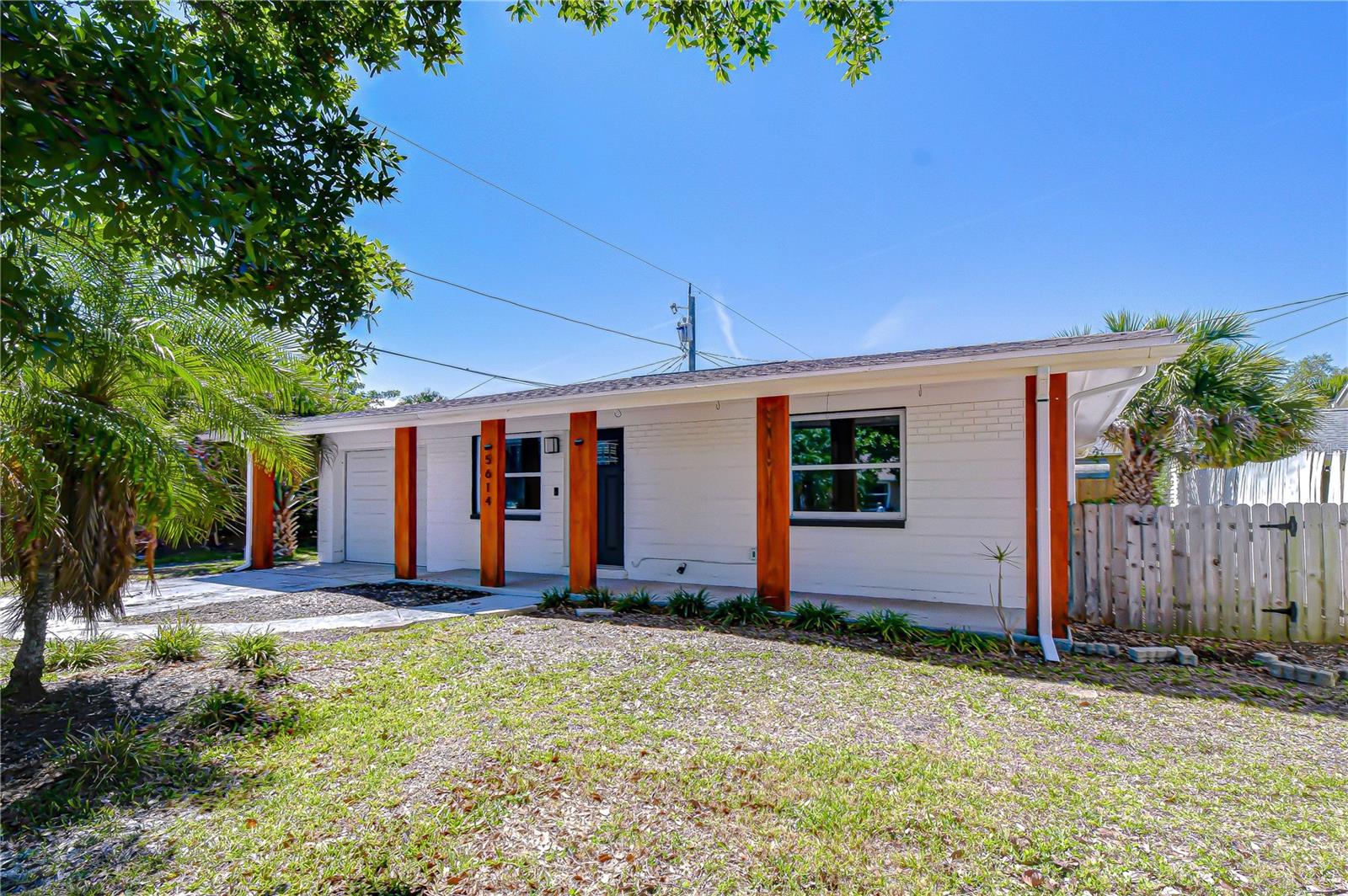 Enjoy coastal breezes from the front porch of this beautifully updated cottage with modern farmhouse style located in vibrant charm of Gulfport’s Arts District. Step inside to a bright and inviting great room featuring polished terrazzo floors and fresh, neutral finishes throughout.  The kitchen has been thoughtfully updated with an open-concept design, showcasing white shaker cabinetry, quartz countertops, subway tile backsplash, and stylish designer lighting. Just off the kitchen, the light-filled dining area creates an ideal space for both everyday living and entertaining.  A tucked-away Florida room offers flexibility as a cozy lounge, home office, or guest space. The spacious primary bedroom features new tile plank flooring, sliding doors leading to the backyard, and a barn door entry to the updated bathroom complete with an oversized, curb-less shower.  Additional bedrooms continue the home’s cohesive design with clean lines and a light, airy feel. Step outside to a private, fully fenced backyard—perfect for relaxing evenings, entertaining guests, or enjoying your own outdoor retreat.  Ideally located just a short distance from Gulfport Beach, Clam Bayou Nature Preserve, and the lively Beach Boulevard Art Walk, you’ll also enjoy easy access to local dining, markets, live music, and the scenic waterfront along Boca Ciega Bay.