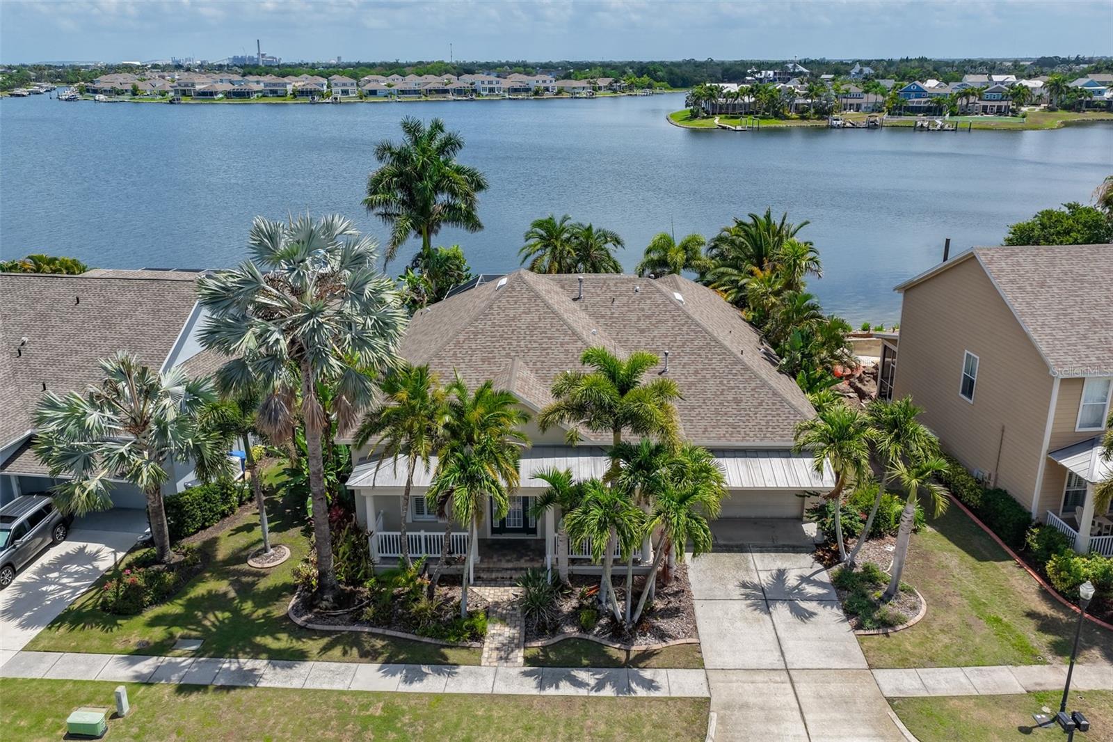 Experience exceptional waterfront living at its finest in the gated, coastal community of MiraBay. Built in 2003, this spacious pool home offers 4–5 bedrooms, 4 bathrooms, and 3,256 square feet of thoughtfully designed living space perfectly positioned on the lagoon with sweeping wide water views. Designed for both comfort and convenience, all primary living areas and bedrooms are located on the first floor, creating an ideal layout for everyday living and long-term ease. The only space located upstairs is a large bonus room complete with a half bathroom, wet bar, and stunning water views perfect as a media room, game room, guest retreat, or flexible entertaining space. A welcoming front porch and impressive entry open to soaring ceilings, crown molding, wood and tile flooring, and expansive living spaces filled with natural light. The oversized kitchen is designed for both everyday living and entertaining, featuring abundant cabinetry, granite countertops, built-in stainless appliances, a large breakfast nook, and seamless flow into the open living areas. The first-floor primary suite is privately situated with tranquil water views and complemented by additional generously sized bedrooms, including a guest suite with its own exterior entrance ideal for visitors or multigenerational living. A dedicated office provides even more flexibility for working from home or additional living space. Step outside to your private outdoor oasis featuring a saltwater heated pool and covered lanai. Enjoy fishing or kayaking from your private dock, where you can add a boat lift and enjoy boating with davit access to Tampa Bay and the Gulf beyond. Additional highlights include a new roof and A/C installed in 2019. As a resident of MiraBay, you'll enjoy world-class amenities including a waterfront clubhouse café, resort-style pool, free use of kayaks, canoes, and paddleboards, gym with fitness classes, pickleball and tennis courts, basketball courts, multiple playgrounds, and more. This home is conveniently located just minutes from E.G. Simmons Park, Apollo Beach Nature Preserve, marinas, and waterfront dining with easy access to shopping, beaches, sports complexes, MacDill AFB, I-75, US 41, I-4, US 301, the Selmon Expressway, St Petersburg, Downtown Tampa, and only about 27 miles to Tampa International Airport. This is more than a home, it’s a lifestyle! Call today to schedule your private tour.