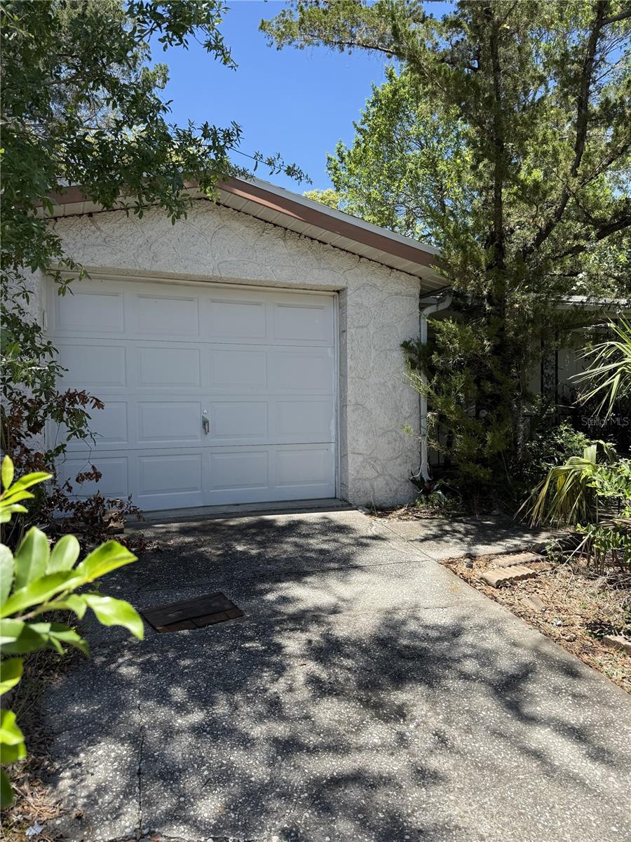 This two-bedroom, two-bathroom home with a one-car garage offers great potential for investors or buyers looking to customize their own space. The roof was replaced in 2021, and hurricane shutters were installed the same year, providing added protection and peace of mind. The property also includes a gas operated generator. The home features a covered front patio, and an enclosed rear patio, adding extra usable space. While the interior is in need of a full renovation, it presents a blank canvas for your vision. The yard is currently overgrown but can be transformed into a beautiful outdoor area. Located outside of the flood zone, this property offers added value and reduced insurance concerns.