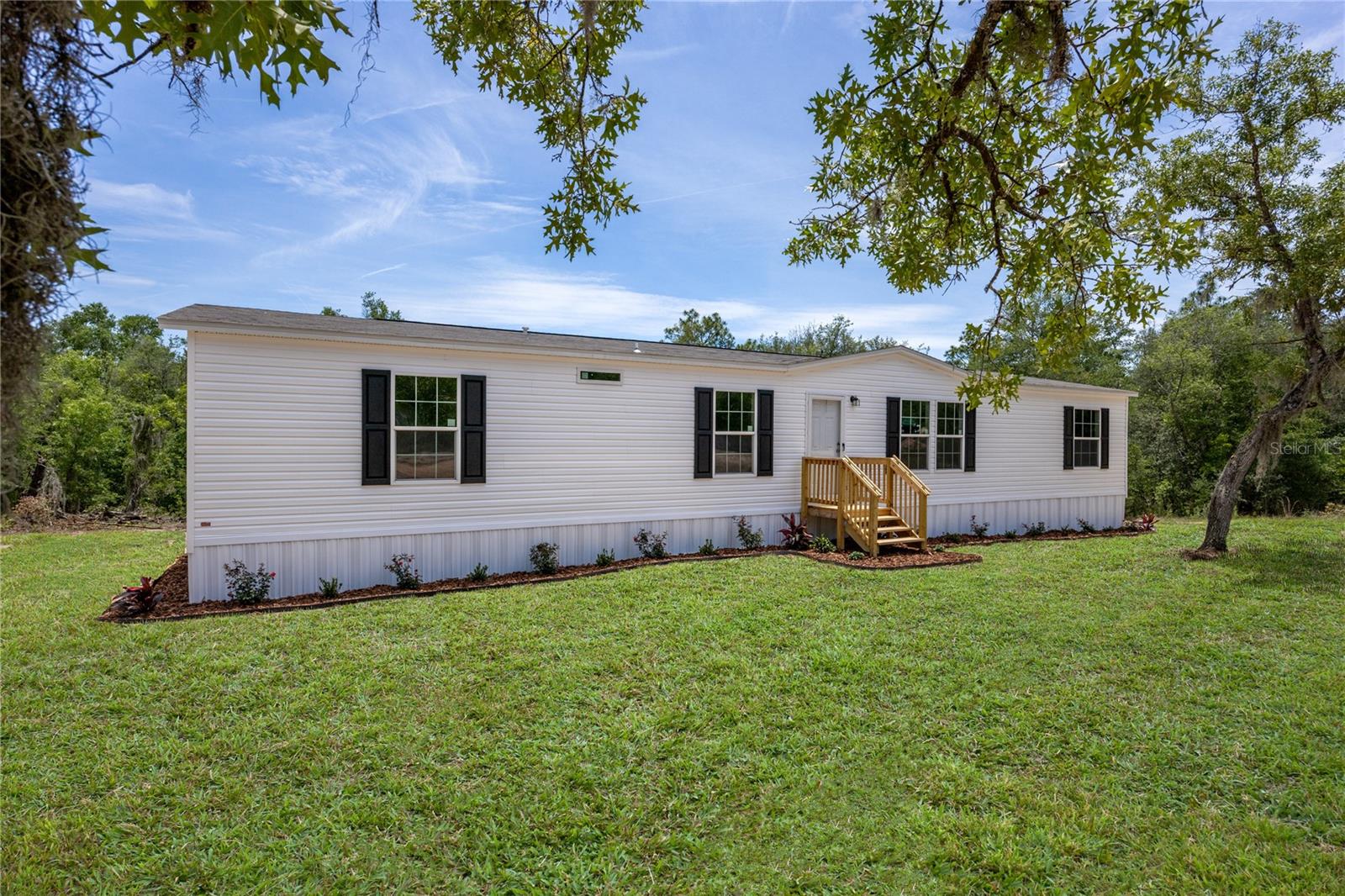 One or more photo(s) was virtually staged. Welcome to this brand new 2026 4 bedroom 2 bathroom home situated on 1.35 acres! Nestled in a tranquil neighborhood, this serene location offers peace and privacy, making it an ideal spot to settle down and create your own haven. The home was just delivered and features high-end materials and craftsmanship. Step inside to discover a thoughtfully designed layout featuring a spacious living room perfect for both entertaining and relaxing, accented by natural light pouring in through windows. The kitchen features new stainless-steel appliances and ample cabinet storage. Adjacent to the kitchen, a laundry room with plenty of room for a washer, dryer, and extra storage racks. The primary bedroom is spacious and includes a walk-in closet. The primary bathroom has a new vanity, step-in shower, and high-end luxury vinyl flooring. This home has a split floor plan, providing a living room and dining room perfect for entertaining and relaxing. On the other side of the home, there are three additional bedrooms and a full bathroom, providing ample accommodation and ample closet space. These additional bedrooms provide versatility for guests. Outside, revel in the beauty 1.35 acre property with a back deck and front steps. The property is mostly cleared land with some trees for added privacy. The property is conveniently located just 7 minutes from downtown Interlachen and less than 30 minutes from Gainesville, which offers ample options for dining, shopping, and hospitals. This is a one-of-a-kind property, so call today to schedule a showing!