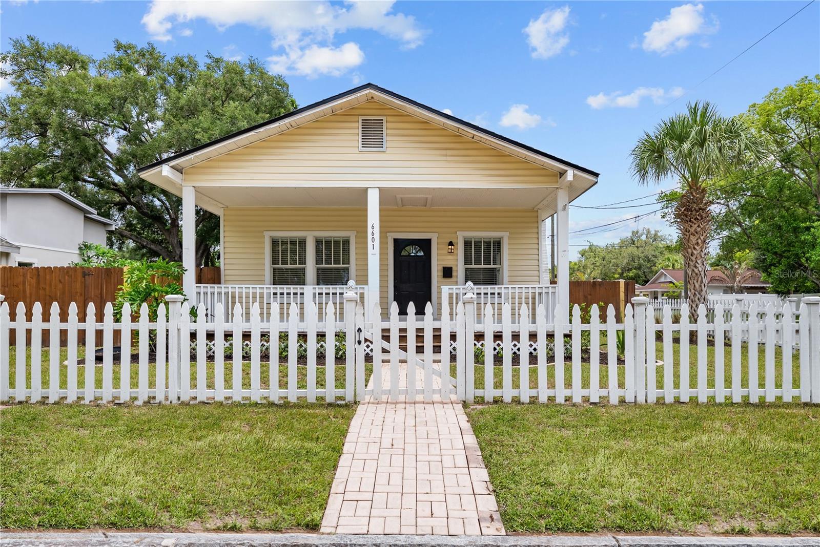 Virtually Staged. Welcome to the heart of Seminole Heights, where this charming Bungalow awaits you. Wellington greets you with its white picket fence, expansive front porch and oversized 70’ x 105’ corner lot. Step inside to discover a roomy 2-bedroom, 2-bathroom home with an abundance of natural light. The living room/dining room combo is great for entertaining, with an updated kitchen featuring solid wood cabinets and stainless-steel appliances along with two spacious bedrooms.  An interior utility closet with washer and dryer makes doing laundry a breeze. Rest assured, with big ticket items replaced recently such as the Roof in 2025, Water Heater in 2024, the A/C in 2020, while ample insulation provides for low utility bills.  The rear porch leads you to a fully fenced back yard, providing privacy and plenty of space to accommodate family and friends. A dual gate enhances your ability to immerse in the Florida lifestyle with ample space to park your boats, jet skis and RVs, along with an outdoor shed providing additional storage. Seminole Heights is home to some of Tampa’s greatest dining establishments and Wellington is located within a leisurely walk from some of its best including: Michelin Award Recipient - Rooster and the Till (0.1 miles), Wicked Oak BBQ (0.1 miles), Mekenita Cantina (0.1 miles), Gulf Coast Sourdough Sandwich Shop (0.1 miles), Nori Nori Craft Handrolls (0.1 miles), The Heights Drive Through (0.1 miles), and Trips Diner (0.3 miles). Seminole Heights’ centralized location allows for easy access to Tampa International Airport, the University of South Florida, Raymond James Stadium, The Tampa Riverwalk, downtown Tampa and Waterstreet with some of the nation’s highest rated beaches including Clearwater Beach, St. Pete Beach, and Caladesi Island within a 45-minute drive. Call today for a showing of this pleasant home in a truly walkable location.