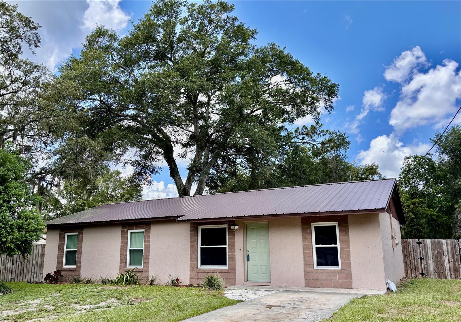 Virtually Staged. UPDATED HOME WITH BONUS ROOM, METAL ROOF & PRIME CENTRAL FLORIDA LOCATION!
 This well-maintained home offers a blend of comfort, efficiency, and convenience. Major updates include a metal roof installed in 2019, new energy-efficient windows (2019), a tankless water heater, and an upgraded higher-tonnage A/C system designed to keep the home comfortable year-round. The former garage has been professionally converted into a versatile bonus room, providing additional living space perfect for a family room, home office, playroom, gym, or guest area. Step outside to enjoy the fully fenced backyard, offering plenty of space for pets, outdoor entertaining, or simply relaxing in your own private retreat. Conveniently located with easy access to both The Villages and Ocala. You'll enjoy nearby shopping, dining, entertainment, and medical facilities.