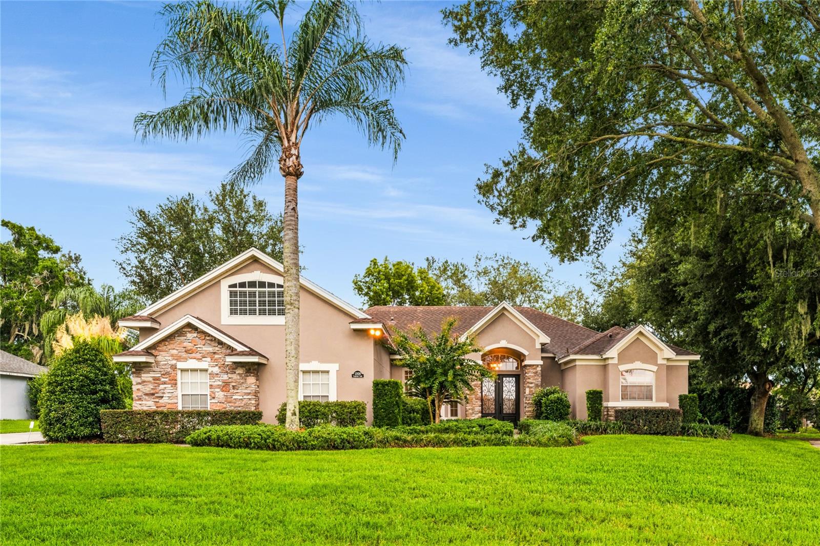 Travel the winding, tree-lined streets along the shores of Lake Minnehaha to Lake Ridge Club, one of Clermont's most exclusive communities. Renowned for its custom homes, oversized homesites, and picturesque park-like setting, this distinctive neighborhood was crafted by Baybrook Homes, celebrated for quality construction and timeless design. Framed by mature trees, lush landscaping, and handsome stone accents, this beautifully maintained residence offers exceptional curb appeal from the moment you arrive.

Leaded glass entry doors welcome you into elegant formal living and dining rooms, where expansive glass doors frame sparkling pool views and fill the home with natural light. The well-appointed kitchen features custom Maple cabinetry with crown molding, Black Galaxy granite countertops, a spacious breakfast bar, and a complete appliance package, all overlooking the inviting family room.

Major updates provide lasting value and peace of mind, including a 2017 roof with solar panels, 2025 A/C, 2022 pool resurfacing, and a transferable Hudson termite bond. The private owner's suite offers crown molding, two California Closet walk-in closets, and a spa-inspired bath with dual maple vanities, a garden tub, and a frameless glass shower. Two additional bedrooms are thoughtfully positioned on the opposite side of the home and feature closet organizers with a shared full bath, along with a third guest bedroom and guest bathroom.

Upstairs, the spacious bonus room provides outstanding flexibility as a media room, game room, home office, or fifth bedroom. Outside, enjoy your own backyard retreat featuring a screened pool, expansive cool deck, covered lanai, serene landscaping, and distant lake views.

Lake Ridge Club residents enjoy private deeded access to Lake Minnehaha and the Clermont Chain of Lakes, complete with a community dock, clubhouse, resort-style pool, and boat/RV storage (per HOA guidelines). Whether boating, fishing, kayaking, or simply enjoying spectacular sunsets, this exceptional community offers the perfect blend of luxury, recreation, and convenience just minutes from shopping, dining, and major roadways.
