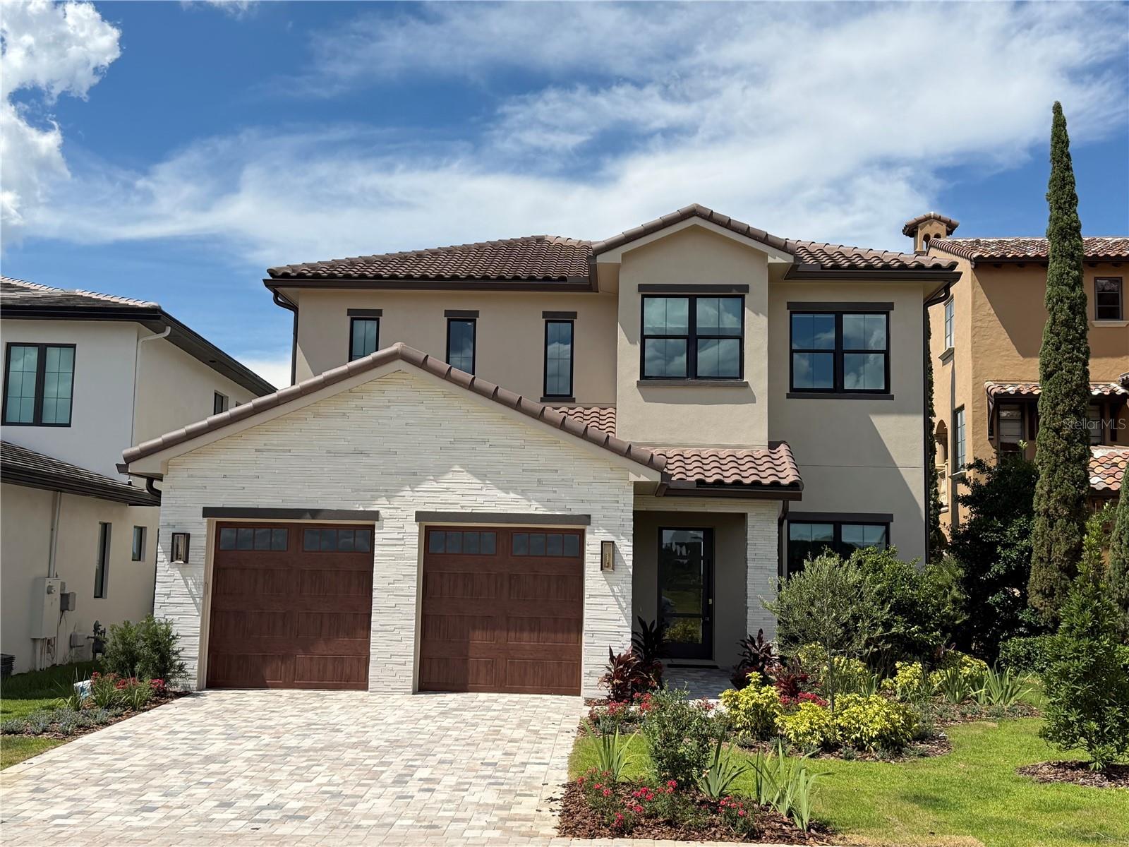 Under Construction. New construction luxury golf villa by Vogel Building Group, ideally positioned within the exclusive gates of Bella Collina. This thoughtfully designed two-story residence blends timeless European-inspired architecture with refined modern finishes, offering a refined yet comfortable lifestyle in one of Central Florida’s most sought-after private communities.

The welcoming façade showcases a harmonious mix of stone and smooth stucco, accented by a dramatic 10-foot entry door and designer exterior lighting. Inside, an open-concept layout creates effortless flow between the family room, dining area, and gourmet kitchen - ideal for both everyday living and elevated entertaining. The kitchen is beautifully appointed with custom cabinetry, premium countertops, statement lighting, and upscale plumbing fixtures, all curated with Vogel’s signature attention to detail.

The main level features a private guest suite with ensuite bath, while the second floor offers additional bedroom suites, a spacious game room, and a versatile loft with bar area - perfect for hosting or relaxing. Elegant flooring selections, curated lighting, and refined trim details elevate every space throughout the home.

Outdoor living is seamlessly integrated with a covered lanai, summer kitchen, and private pool, creating a true indoor-outdoor lifestyle. An upstairs deck further enhances the home’s livability, offering additional space to unwind and enjoy the surroundings.

Located in Bella Collina, residents enjoy access to world-class amenities including a Sir Nick Faldo-designed championship golf course, full-service spa, fitness center, tennis, pickleball, dining, and a vibrant social lifestyle - all just minutes from Orlando and major travel corridors.

A rare opportunity to own a brand-new, designer-curated Vogel home in a premier golf and lifestyle community. Schedule your private showing today. Developer will defer the $40,000 Sports Membership Deposit.
