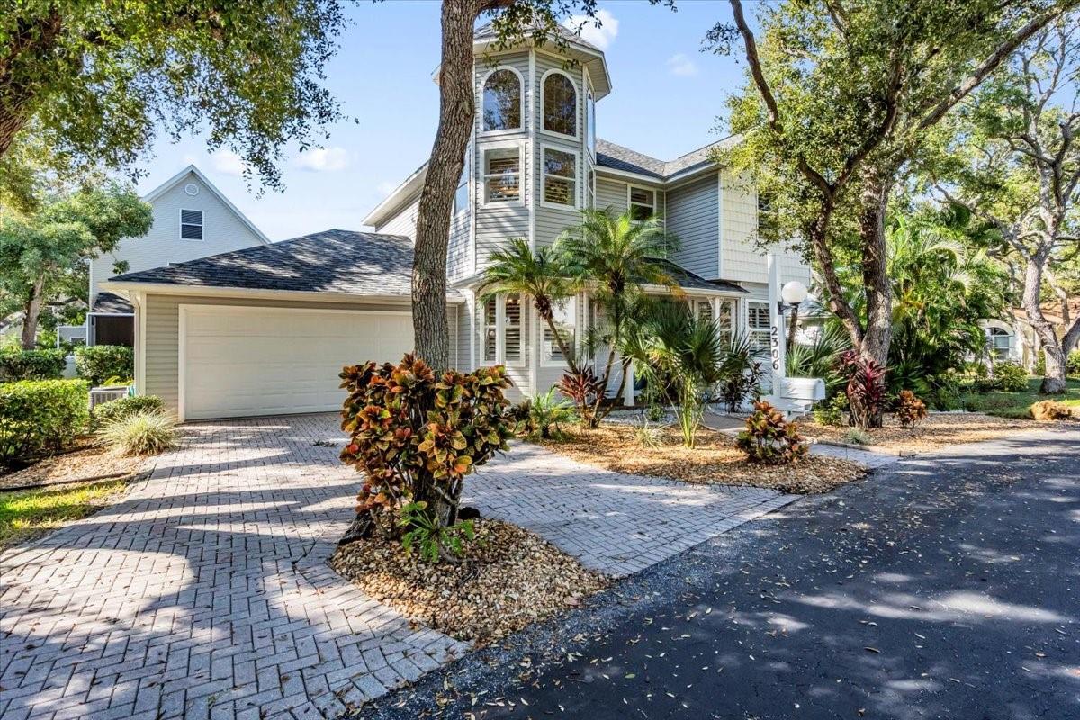 Beautifully updated and truly maintenance-free, this former model home sits in the heart of Cape Town Village, an intimate, oak-canopied community of just 42 New England-style residences. Designed for effortless living, this single-family home blends timeless charm with modern upgrades throughout. Step inside to a bright, airy living room enhanced by vaulted ceilings and updated hardwood floors. All three bedrooms have plush carpet, and Hunter Douglas plantation shutters add elegance and privacy to every space. The kitchen features updated quartz countertops, a new sink and faucet, upgraded disposal, and a full suite of 2022 Frigidaire Gallery appliances. All three bathrooms have been refreshed with quartz counters and contemporary fixtures. The primary suite stands out with a beautifully redesigned walk-in shower featuring frameless glass. Additional enhancements include a Culligan water softener, an updated Rheem water heater, Minka Air ceiling fans, updated lighting, new gutters with stainless steel leaf guards, landscape lighting, and an ADT security system to ensure both comfort and peace of mind. Cape Town Village provides maintenance-free living, covering all ground maintenance, irrigation, internet, cable, and upkeep of the community pool, located just steps from your front door. Conveniently located near Blake Hospital, GT Bray Park, and the beaches of Anna Maria Island.  HOA docs available through weblink.