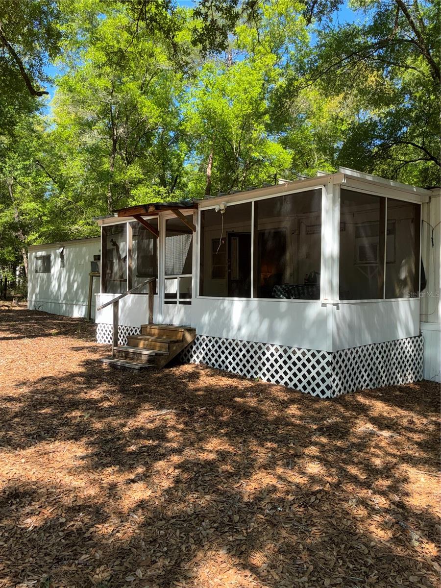 Build, Camp, & Explore with No HOA! Escape to your own 1-acre private outpost tucked into the beautiful Ocala National Forest! If you are dreaming of a lifestyle centered around Florida's best outdoor recreation, this high-and-dry, fully field-fenced lot is your ultimate launchpad. You are just 20 minutes from diving into the crystal-clear waters of Alexander Springs and only 15 minutes from launching your boat at the DeLand boat ramp. Whether you are looking for a peaceful weekend retreat, a permanent nature-lover's residence, or a place to live while you build a custom forest cabin, this property offers unmatched freedom. You can even expand the family setup immediately by adding an RV to the lot, thanks to the ready-to-use 30 AMP hookup. Best of all, with absolutely no HOA restrictions and no major subdivisions across the street, you enjoy total privacy. You also get the perfect blend of rural peace and modern convenience, with an expanded grocery Dollar General just 4.7 miles down the road. While the location is wild at heart, the setup is incredibly practical and completely build-ready. A cozy, fully livable 2-bedroom, 1.5-bath single-wide (720 sq ft) sits on the property—perfect for immediate use or cosmetic updates. The expensive infrastructure is already done: impact fees are paid, a high-performance deep-water well is installed, and Spectrum internet is available.