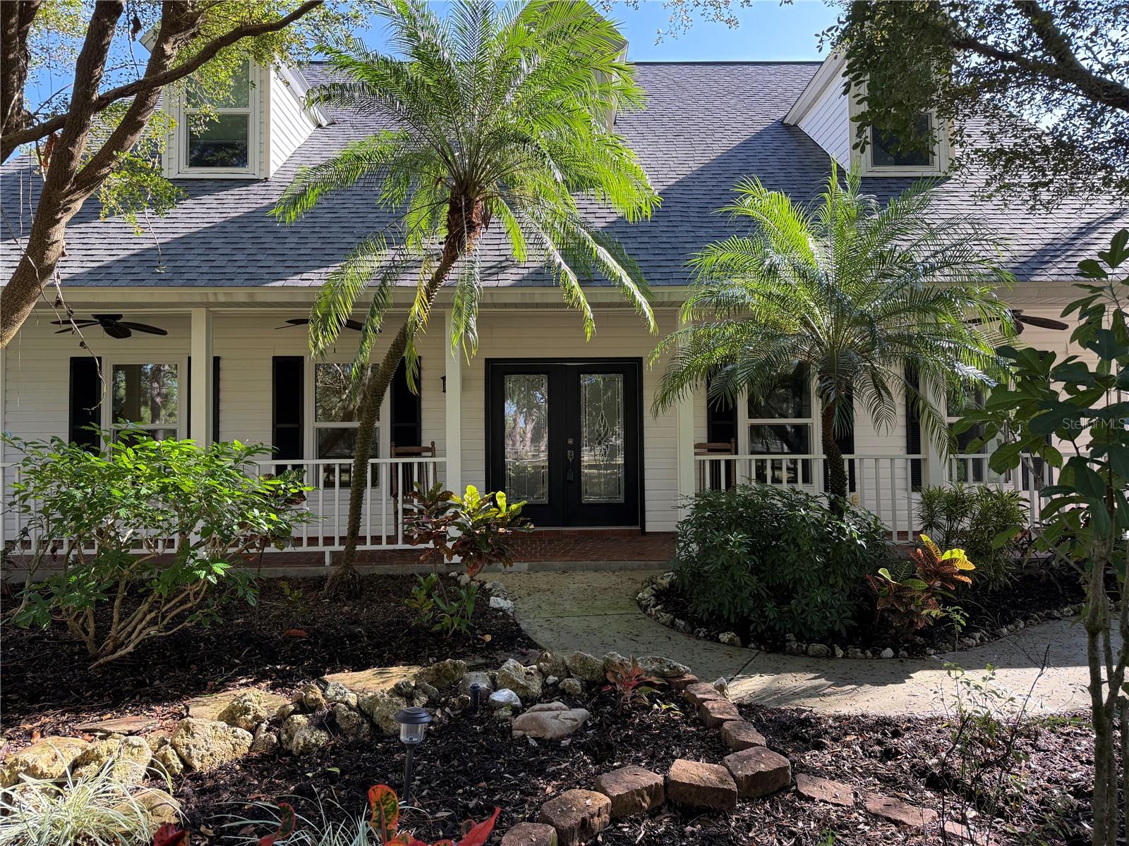 Experience luxury, privacy, and peace of mind in this stunning 5 bedroom 4 bathroom estate crafted by renowned builder Roland Yoder, set on over 9 wooded acres in Panther Ridge. Featuring 4,111 SF of living space, this custom home includes a remodeled kitchen with bamboo cabinets, granite counters, and stainless appliances, a luxurious first-floor primary suite, oak floors, and impact-rated doors/windows throughout. Recent upgrades ($300K+) include a new roof (30-yr warranty), HVAC, water heater, septic, pool pump, propane tanks, and more. Enjoy resort-style outdoor living with a heated pool/spa with travertine tiles, summer kitchen, travertine deck, fire pit, tiki hut, tropical gardens, and two massive outbuildings: a 6-stall concrete block barn with a metal roof and hurricane ties, as well as an oversized workshop. Plenty of space for the whole family and your four legged friends. Fully fenced with 4 pastures and access to 15 miles of trails, this rare property offers unmatched style, function, and storm resilience and is just minutes from Lakewood Ranch.