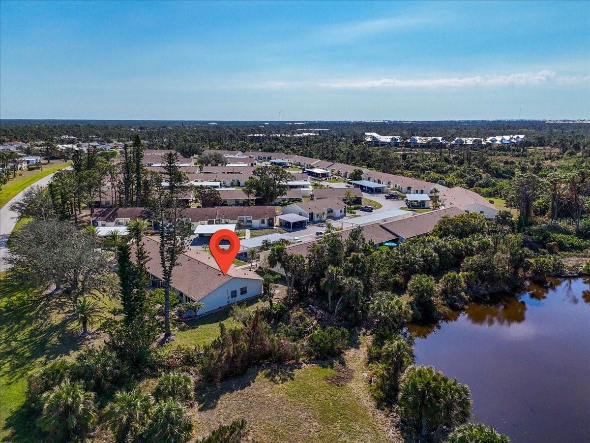 WOW over $20K PRICE REDUCTION on this Stunning MAINTENANCE-FREE 55+ Condo with Serene Views and Modern Comforts! This home is now an EXCEPTIONAL VALUE and flood insurance is not required. Casual elegance meets nature in this BEAUTIFULLY FURNISHED end-unit condo with 2 bedrooms and 2 bathrooms. A perfect sanctuary for relaxation and rejuvenation including an HOA that takes care of the mowing, exterior repairs and more! This PRIVATE and COVETED LOCATION within the community is just seconds away from the Wildflower Preserve for wildlife viewing and nature hikes. Inside find an updated open-concept living/dining area with cathedral ceiling and sightlines to the large back wall of sliders that let in a bounty of light. BONUS: the large dining room window is exclusive to end units. Attractive vinyl plank flooring and premium lighting and fans enhance the modern aesthetic. A standout feature is the 4-season Florida room, which has been enclosed and modified for seamless step-free entry. A galley kitchen provides all the appliances and countertop space you’ll need to prep and cook meals. The spacious primary suite includes an ensuite bathroom with a walk-in shower and a split bedroom plan ensuring privacy for all. A 2nd bedroom suits guests well with a nearby 2nd bathroom. The patio backs to a lovely blooming orchid tree and is an ideal spot for outdoor entertaining or simply soaking in the tranquil surroundings. Plenty of storage space in the hall closet, interior laundry room and accessible attic space. The dedicated carport and storage shed provide protection for your vehicle, beach chairs and sports gear. The plumbing has already been re-piped overhead, a new breaker panel installed in 2024 and a new roof in 2023. The Village at Wildflower community has a heated pool and is located close to Gulf beaches, historic Boca Grande, restaurants, grocery stores, and essential medical services. For those who love outdoor activities, you'll find hiking trails right next door and several golf courses nearby. Enjoy easy access to parks, farmers markets, festivals, and live music on Manasota Key and Dearborn Street. Whether you're looking for a permanent residence or a seasonal getaway, this condo offers everything you need for an active lifestyle combined with peaceful living. Don’t miss the chance to secure both comfort and privacy at an incredible value, complete with beautiful furnishings ready for you to enjoy. Schedule your private showing today!