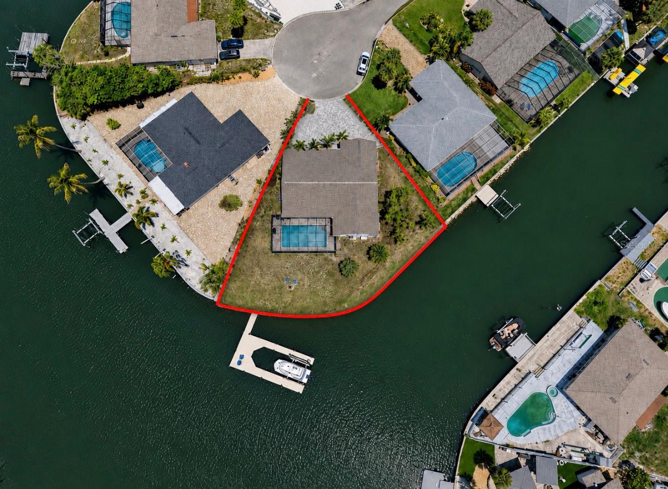 Waterfront Living Without Compromise | 170 Feet of Seawall | Direct Tampa Bay Access

If you've been searching for the ultimate Apollo Beach boating property, this is the one that checks every box....with views of St Pete from your backyard! No HOA, no CDD.

Perfectly positioned on an oversized corner cul-de-sac lot on coveted Bal Harbor Island, this waterfront pool home boasts approximately 170 feet of seawall, a 48-foot long, wrap around, deep-water dock, and a 13,000-pound boat lift; providing ample space for your cabin cruiser, offshore fishing boat, sailboat, jet skis, kayaks, and all the water toys that make Florida living unforgettable.
From your backyard, enjoy direct, no-bridge access to Tampa Bay in minutes. Cruise to waterfront restaurants, spend the day fishing the bay, watch dolphins and manatees play in the canal, or simply relax as the annual holiday boat parade glides past your dock.
Inside, this renovated 4-bedroom, 2-bathroom pool home offers nearly 2,000 square feet of thoughtfully designed living space. A nearly complete remodel transformed the home into a modern coastal retreat, including impact windows throughout, a newer roof, HVAC system, plumbing, electrical, insulation, drywall, water heater, garage door, and more.
The heart of the home is the stunning open-concept great room featuring a redesigned chef's kitchen with a large center island, abundant cabinetry, and seamless flow into the living and dining spaces. Wood-look ceramic tile flooring extends throughout the entire home, creating a cohesive, low-maintenance design with no carpet anywhere.
Four pocket sliding glass doors invite the outdoors in, opening to a spacious covered lanai and screened pool enclosure surrounded by elegant travertine pavers. Whether entertaining guests or enjoying quiet evenings by the water, this home was designed to maximize its incredible waterfront setting and capture refreshing coastal breezes year-round.
The expanded owner's retreat serves as a private sanctuary, complete with a spa-inspired en-suite bath featuring a zero-entry shower, private water closet, walk-in closet, and direct access to the pool and waterfront through its own pocket slider.
Additional highlights include EV charging capability in the garage, a palm-lined pavered driveway, crown molding, recessed lighting, updated dock and seawall improvements, and a higher elevation than many neighboring homes, providing added peace of mind.
With no HOA, no CDD fees, and a location just minutes from waterfront dining, the Apollo Beach Nature Preserve, and the Manatee Viewing Center, this is more than a home; it's a front-row seat to the Florida boating lifestyle you've been dreaming about.
Waterfront dining is a local favorite, with several restaurants accessible by boat for a truly coastal experience. Healthcare options include nearby South Bay Hospital, Brandon Regional Hospital, and a wide range of medical providers throughout the South Shore area. With quick access to I-75, commuting to Tampa, Sarasota, and Orlando is easy, and Tampa International Airport is within comfortable driving distance.