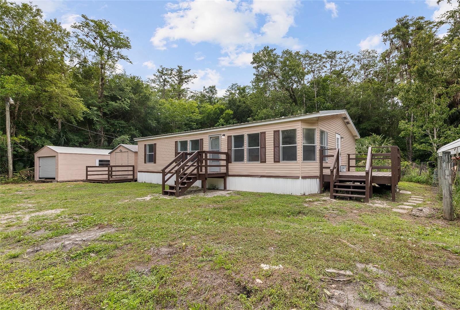 Tucked away on over an acre of beautifully wooded land, this charming manufactured home offers the perfect blend of privacy, space, and country living. Surrounded by mature trees and natural scenery, you'll enjoy a peaceful setting with plenty of room to relax, entertain, or simply unwind away from the hustle and bustle.
Inside, the home features a spacious and functional layout with 2 full bathrooms and an inviting living area designed for comfortable everyday living. The kitchen is the heart of the home, complete with a large center island that provides additional prep space, seating, and storage--perfect for gatherings and daily convenience. 
Step outside and take advantage of everything this property has to offer. One of the detached sheds provides ample room for hobbies, or workshop space, while the additional storage shed offers even more flexibility for tools, equipment, or outdoor essentials. With so much open space, there's plenty of room for gardening, recreation, or future improvements.
Whether you're looking for a private homestead, weekend retreat, or affordable home with land, this property delivers the tranquility and freedom you've been searching for while still offering the comforts of home.