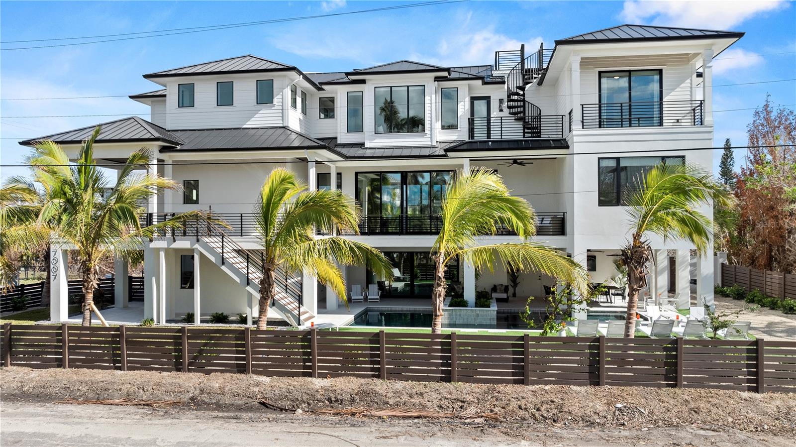Investor's Dream - Short term rentals allowed here at this amazing Siesta Key home. Designed specifically to cater to large groups, this brand new home comes fully furnished and ready to produce an impressive income. Just steps away from Siesta Key's public beach access onto Crescent Beach, all the boxes are checked here. 8 bedrooms, all en suite with 8 bathrooms and a powder room too. Amazing resort style pool & spa boasting a rain/waterfall feature and impressive outdoor living. Luxury finishes are seen throughout such as an elevator, high end appliances, solid wood cabinetry, stone surfaces, bar, oversized island, and more!