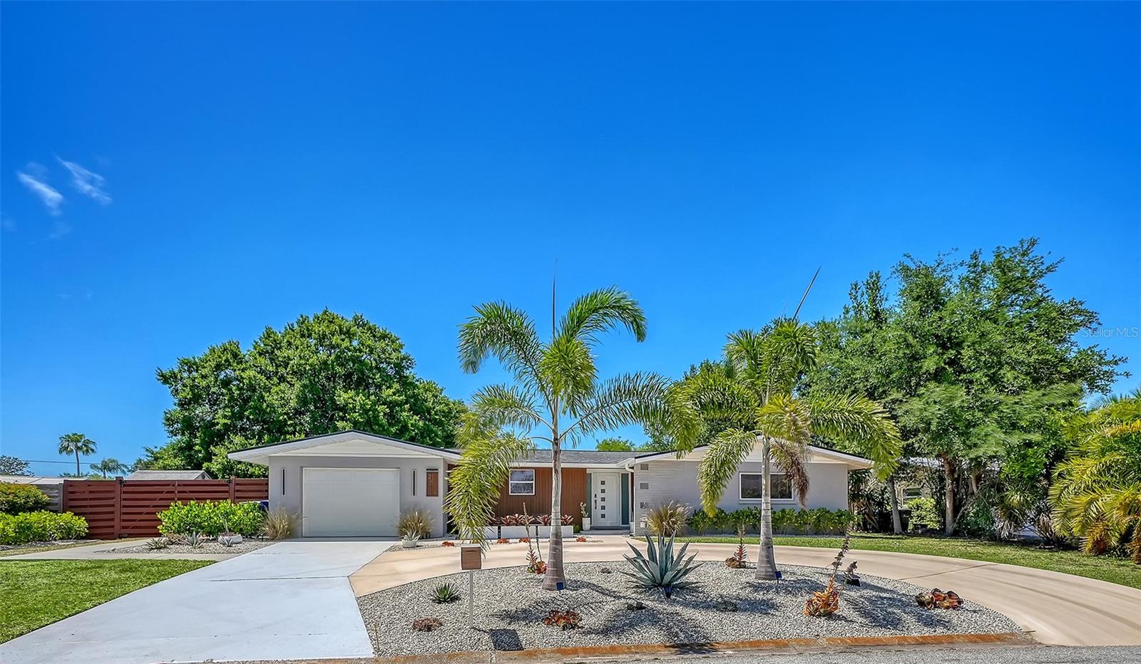 Modern Luxury Meets Mid-Century Charm in the Heart of Southgate.
Prepare to be captivated by this Mid-Century Modern gem, situated on nearly a quarter-acre in one of Sarasota’s most sought-after neighborhoods. This 3-bedroom, 2-bathroom residence with a dedicated office offers a rare combination of refined design and true “big-ticket” peace of mind. Step inside over freshly restored and sealed terrazzo floors and into a sun-drenched, open floor plan. The chef’s kitchen features crisp quartz countertops, premium Bosch appliances, and custom cabinetry. The dining area is a true conversation piece, showcasing a contemporary wood-accent wall with a seamlessly integrated jib door that reveals a brand-new, dedicated LAUNDRY SUITE (2024), complete with an abundance of custom storage and a sink. Every detail throughout the home has been thoughtfully addressed, from new baseboards to freshly painted ceilings (2026).
This home has an extensive list of upgrades in recent years: Roof: brand new in 2025, including TPO on slanted surfaces. HVAC (2023), new ductwork and new full attic insulation (2024); new water heater (2025); new electrical panel/fuse box (2024). Plumbing: Pipes professionally relined (March 2024); new gutters and French drains installed. The exterior transformation (2024–2025) is equally impressive. A new circular driveway and paved walkway lead to a modern, refaced façade and a striking new front door. The front yard has been thoughtfully redesigned with new landscaping and enhanced by solar-powered exterior lighting. The oversized, fenced backyard offers exceptional space for a future pool and expansive outdoor living. A brand-new screened lanai (2024) and new shed complete this private outdoor retreat. Located just minutes from Sarasota Memorial Hospital, Southside Village, and downtown Sarasota, this Southgate standout is truly move-in ready. With so many upgrades and abundant room to personalize the outdoor space, the only thing left to do is move in and enjoy the Sarasota lifestyle!!! COME AND MAKE THIS HOUSE YOUR HOME!!!