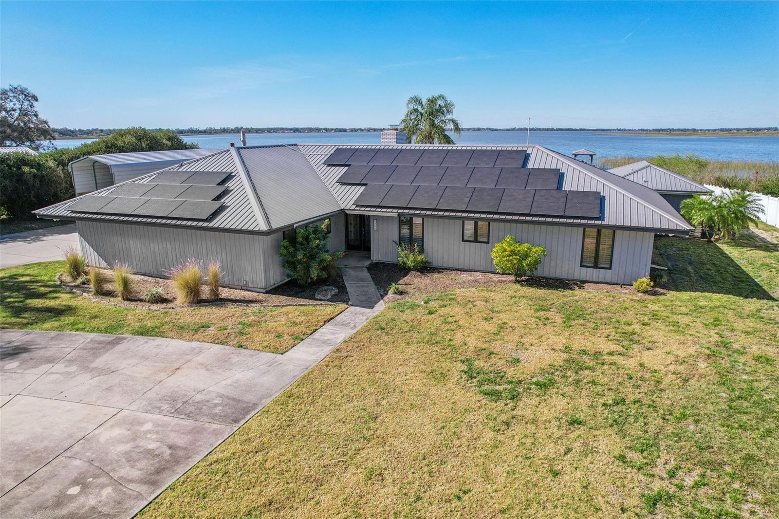 Welcome to this exceptional lakefront property at 3050 Crump Rd in Winter Haven, offering space, versatility, and direct access to the lifestyle Central Florida is known for. Situated on approximately 1.08 acres along Lake Hamilton, this residence combines a thoughtfully updated main home with a private guest studio, outdoor living, and boating amenities.

The main home features three bedrooms and two bathrooms with an open and functional layout. A bonus room with built in entertainment cabinetry and surround sound opens through double sliding doors to the pool deck, creating seamless indoor-outdoor living. The living room showcases beautiful wood beams, a wood burning brick fireplace, and triple sliding glass doors overlooking the pool and lake. Tile flooring runs throughout the main living areas, with wood flooring in the bedrooms.

The kitchen is designed for everyday living and entertaining, featuring granite countertops, updated cabinetry with pullouts, a large island, built in desk space, wine refrigerator, stainless steel appliances, and a built-in oven/microwave combination. 

A separate guest studio apartment adds flexibility, complete with a kitchenette and triple sliding glass doors leading directly to the pool area. This space is ideal for guests, extended household needs, or flexible use.

Outdoor features include a screened pool with new heater and an 8-foot depth, a spa that conveys, and a gas fireplace on the patio with underground piping in place (propane tank has been removed, but can easily be replaced by the new homeowner). The pool screen was recently replaced. The property includes a private boat dock and lift, allowing easy access to Lake Hamilton and nearby lakefront restaurants by water. Additional highlights include fruit trees in the front yard, RV parking for up to 31 feet with additional storage space, and a metal roof.

Practical upgrades and systems include a new air conditioning system installed July 2024 with annual maintenance, water softener, well for irrigation, public water for the home, an inside laundry room, and a 2-car garage. The hot water heater was installed in 2011. Septic service was last completed June 2023.

Solar panels are leased at $381.75 per month, with an average Duke Energy bill of approximately $30 per month. Televisions in the main living areas convey, excluding bedrooms.

This lakefront retreat offers privacy, functionality, and a connection to the water, all set along beautiful winding roads in a peaceful Winter Haven setting.