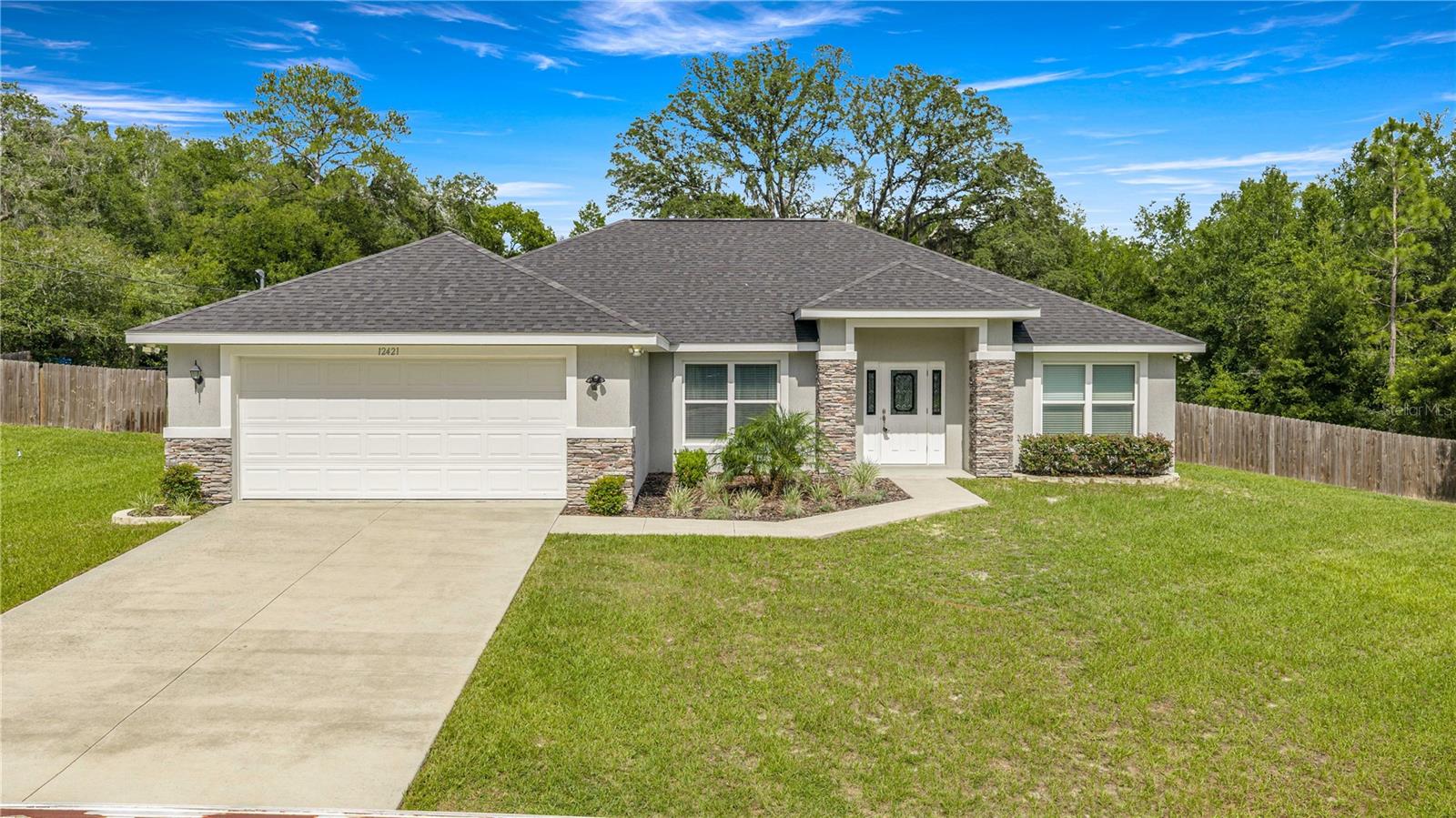 Meticulously maintained, FURNISHED, and freshly painted, this Belleview Retreat is the ONE! Welcome to the peaceful, private 3-bedroom, 2-bath haven situated on a lush 1-acre lot. Enjoy maximum privacy with no rear neighbors, as the property backs up to a serene wooded preserve. Featuring a desirable split-floor plan, the tripled lighted front door opens into a grand open concept great room and dining area perfectly positioned for entertaining. The professionals kitchen has a spacious center island with plenty of seating and tons of storage, granite countertops, crown topped wood cabinets, stainless appliances - including a double oven, with ample pantry and storage space. Peering from the kitchen into the Great Room you will notice vaulted ceilings, luxe furnishings and french doors for easy access to the covered lanai and sprawling, fenced, full sodded backyard. Split-plan living with a refreshing primary suite, featuring a massive walk-in closet with built-ins, and dual sliding barn doors for an added touch of charm . The stunning freestanding soaking tub rests against a dramatic, stone feature wall, creating a luxurious spa-like sanctuary. The ensuite master bathroom features oversized double vanities, full tiled zero entry shower and separate water closet. Two spacious guest bedrooms with the front bedroom doubling as an office. Large indoor laundry and storage area, 5 inch baseboards and molded door and window frames, natural light, ceiling fans, sealed garage floor, extra garage storage, insulated garage door and wired-in security system are part of what makes this home a must-have. All of these features and just miles from restaurants, shopping and hospitals. Call for your showing today. This beauty won't last!
