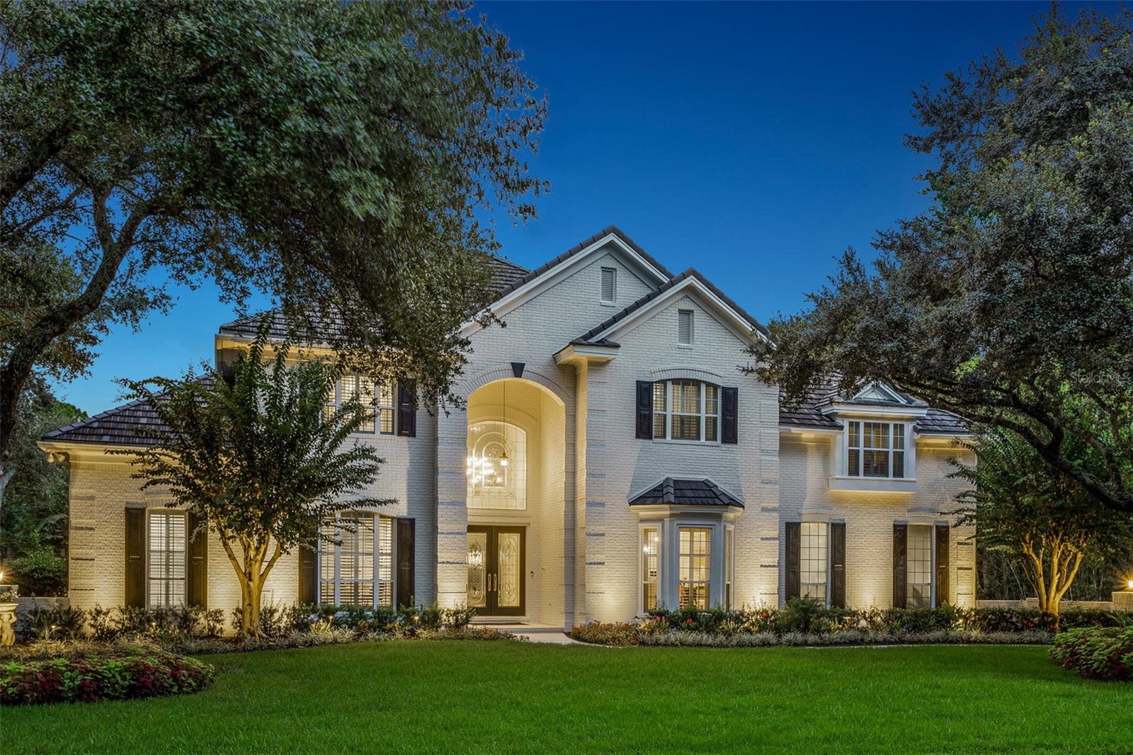 Step into your dream home in the exclusive Reserve at Tampa Palms, a private gated community offering luxury, privacy, and 24-hour security. This 6,590 SF estate on just under half an acre offers everything you’ve ever wanted. Surrounded by a tranquil pond and conservation in the back and conservation in the front, this home provides ultimate privacy with no front or rear neighbors. With 5 bedrooms, 5.5 baths, a private study, pool, spa, and a 3-car garage, this home was meticulously updated in 2022-2023 to balance modern elegance with relaxed livability. Grand double doors lead to a dramatic 2-story foyer with 30-foot ceilings, a dazzling chandelier, and polished 31"x31" marble floors that flow throughout. A 350-bottle, dual-sided, climate-controlled wine wall divides the formal dining and living rooms while adding artistic sophistication. The formal living room features sliding doors with a grand arched transom window above, ceiling-to-floor custom drapes, and expansive glass that floods the space with natural light, creating an airy ambiance with stunning views of the pool, spa, and serene pond. The chef’s kitchen is designed for both beauty and functionality. It boasts a Viking 8-burner gas range and ovens for a total of 3.5 ovens, a Sub-Zero refrigerator, Miele built-in steamer, dual LG dishwashers, two Viking chill drawers, and a farmhouse sink. At its center is a 9' x 10' granite island with abundant storage. Adjacent are a pantry and laundry room with ample organizational space. The family room features a stunning glazed tile wall with a gas fireplace, motorized shades, and custom drapes, offering a cozy yet elegant gathering space. Nearby, the fully renovated pool bath showcases artistic tile and custom cabinetry. The downstairs primary suite is a serene retreat with a sitting area, gas fireplace, motorized shades, custom drapes, and walk-in closets. The spa-like bath includes a walk-in shower, jetted tub, and dual vanities. Just outside is a beautiful study with custom built-ins, ideal for work or quiet reflection. Upstairs, four bedrooms include three with ensuite baths and one designed as a media or game room. A front and back staircase ensures smooth flow throughout. Step outside to the expansive screened lanai with a heated pool and spa, overlooking the pond and lush landscaping. This private backyard oasis is perfect for relaxing or entertaining. This home also includes a tile roof (2019), 3.5 air-conditioning units (within 5 years), 3 hot water heaters (2020), a water filtration system (2021), a Sonos sound system, and a walk-in attic offering additional storage. Located in the exclusive Reserve at Tampa Palms, this community combines upscale living with Florida’s laid-back lifestyle. Compton Park, part of Tampa Palms, offers exclusive amenities for residents, including a Junior-Olympic pool, children's pool, tennis, pickleball, and basketball courts. The park features a playground, picnic areas, open fields, a scenic pond. Conveniently close to schools, major highways, shopping, hospitals, and Tampa Palms Golf and Country Club, the community offers tree-lined streets, walking paths, and tranquility. Don’t miss the opportunity to make this exceptional home yours.