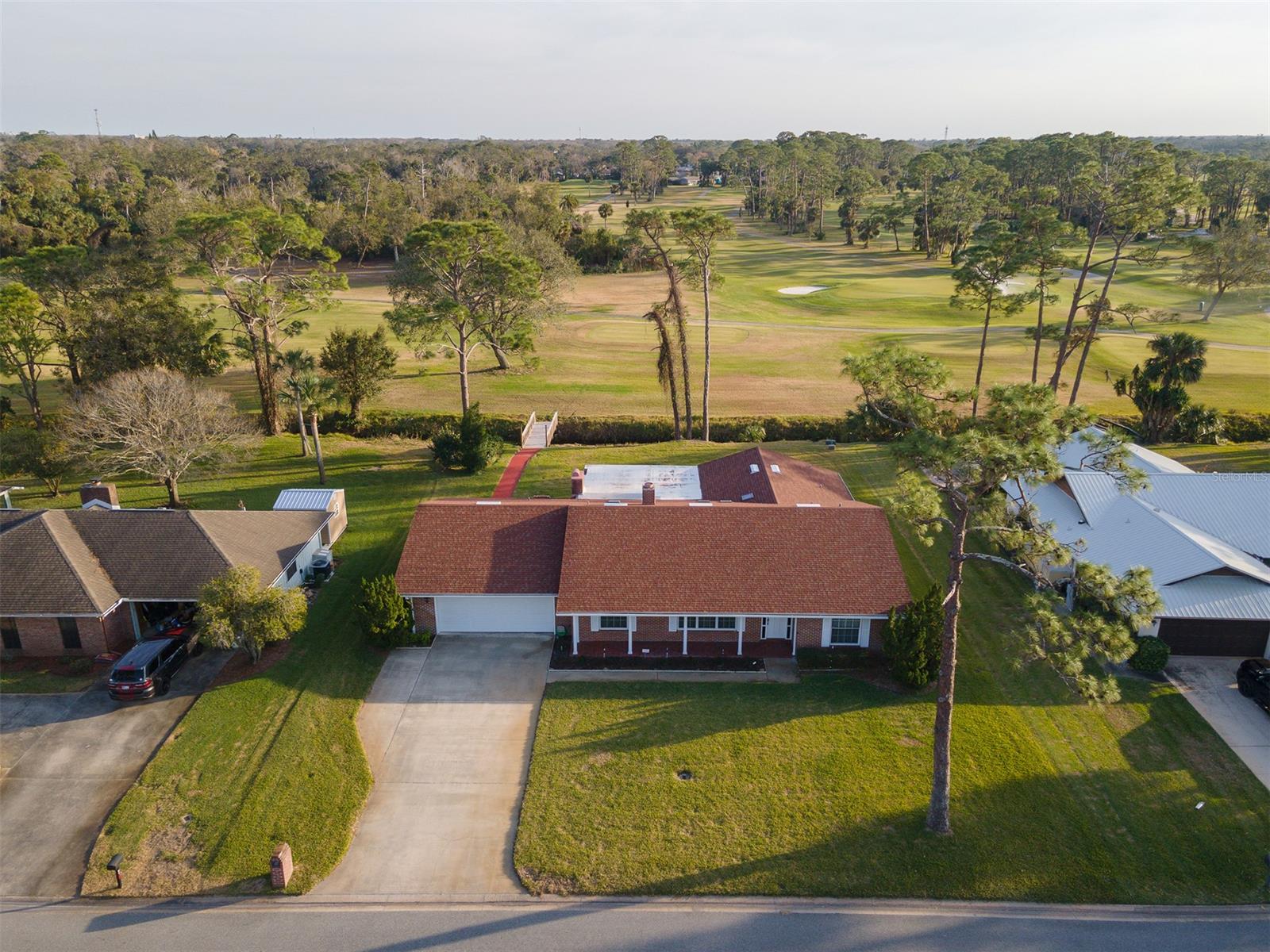 They don't make them like this anymore! Custom built brick golf course home overlooking the 4th tee of the New Smyrna Beach Golf Club with NO HOA. This home has been meticulously maintained by the original owner and the lot is simply spectacular! Bring your vision and make this the home of your dreams. The family room overlooking the golf course is sure to be the entertaining hub for friends and family offering original solid wood ceiling beams, a gorgeous brick wall with wood burning fireplace and heatilator, skylights for natural light, and a custom wet bar. Sliding glass doors from the family room lead out to the extensive enclosed patio with pristine tongue and groove ceiling and built-in grill. All rooms are spacious including the primary en-suite with backyard access overlooking the grounds, a custom cedar walk-in closet, and hidden closet with safe. Tons of storage and closet space throughout and a large laundry room with cabinetry and double stainless steel sink. The car enthusiast will appreciate the oversized garage with plenty of room for 2 vehicles, golf cart, and workshop. Double doors open from the back of the garage onto a paved driveway and deeded wood bridge over the city maintained canal for direct access to the golf course. Notable customizations and features include 2 HVAC systems (2020), hot water heater 2021, gutters, attic fan, central vac system, jetted tub in the guest bath, well for irrigation, Circulator for instant hot water, monitored security system, extended driveway, and safety floor drains in the laundry room and porch. Centrally located close to shopping, trendy restaurants, and the white sandy beaches of NSB! All sizes are approx. All information deemed accurate but ca ;Water: City