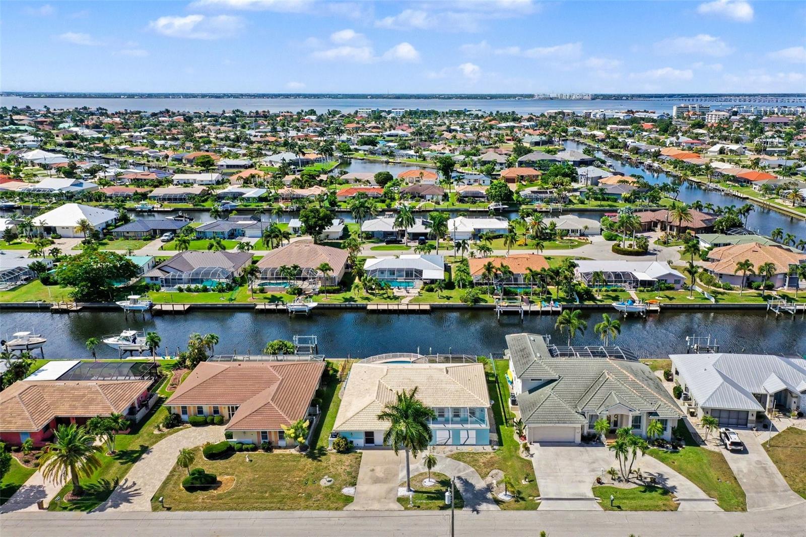 Virtually Staged. Welcome to this beautifully transformed waterfront pool home in Punta Gorda Isles (PGI), where classic Florida architecture meets a modern, coastal interior renovation. Located near the end of a quiet cul-de-sac street near downtown Punta Gorda, and just minutes from the open water, this 3-bedroom, 2.5-bath canal-front home offers classic PGI charm where you can move in and instantly experience waterfront living!
The interior has been opened up to create a brighter, more spacious flow for today’s lifestyle. Smooth Level 5 drywall finishes, clean white walls, recessed LED lighting, continuous light tile flooring, new interior doors and trim, updated electrical fixtures, remote-control ceiling fans, and fresh interior paint all work together to give the home a clean, airy, modern feel.
At the center of the home, the remodeled kitchen anchors the main living spaces and opens to both sides of the floor plan. One side flows into the living and dining area, while the opposite side connects to a family room with a custom built-in bar area. The kitchen features real wood soft-close cabinetry, high-end quartz countertops, a large breakfast bar, and upgraded KitchenAid appliances, including a downdraft oven and built-in drawer microwave. The built-in family room bar includes cabinetry, quartz countertop, tile backsplash, under-cabinet lighting, sink, and a dual-compartment wine and beverage chiller — an ideal feature for entertaining or creating a separate gathering space.
The split-bedroom layout offers privacy and flexibility, with the primary suite positioned on one side of the home and two guest bedrooms on the opposite side. Both the primary and guest bathrooms are fully remodeled with quartz-topped vanities, soft-close cabinetry, updated plumbing fixtures, LED mirrors, and stylish coastal tile work.
Outdoor living is a major highlight. In front, a distinctive screened courtyard-style patio creates a private, protected sitting area before you even step inside — perfect for morning coffee, reading, relaxing, or welcoming guests with a glass of wine. In back, the spacious screened lanai functions like an outdoor living room and dining room with views of the open-air pool, canal and surrounding waterfront homes. New PGT hurricane impact-rated sliding doors create an easy flow from the interior living spaces to the lanai, and new M/I hurricane impact-rated windows w/energy efficient glass can be found throughout the home for your comfort.
The pool area has been beautifully refreshed with new tile, coping, pool deck pavers, and an LED pool light. The open-air pool setting gives the backyard a relaxed resort-style feel, with canal views, sunset backdrops, and room to enjoy outdoor entertaining after a day on the water. The backyard is fully fenced and includes spring-loaded gates with child-proof safety latches for added peace of mind.
Boaters will appreciate the 80 feet of city-maintained concrete canal seawall and quick access to open water, with an estimated 6-8 minute ride to where the Peace River meets Charlotte Harbor (and then the Gulf). The canal outlet is conveniently located near Fishermen’s Village and charming downtown Punta Gorda. PLEASE LOOK AT THE HOME HIGHLIGHTS IN THE ATTACHMENTS.