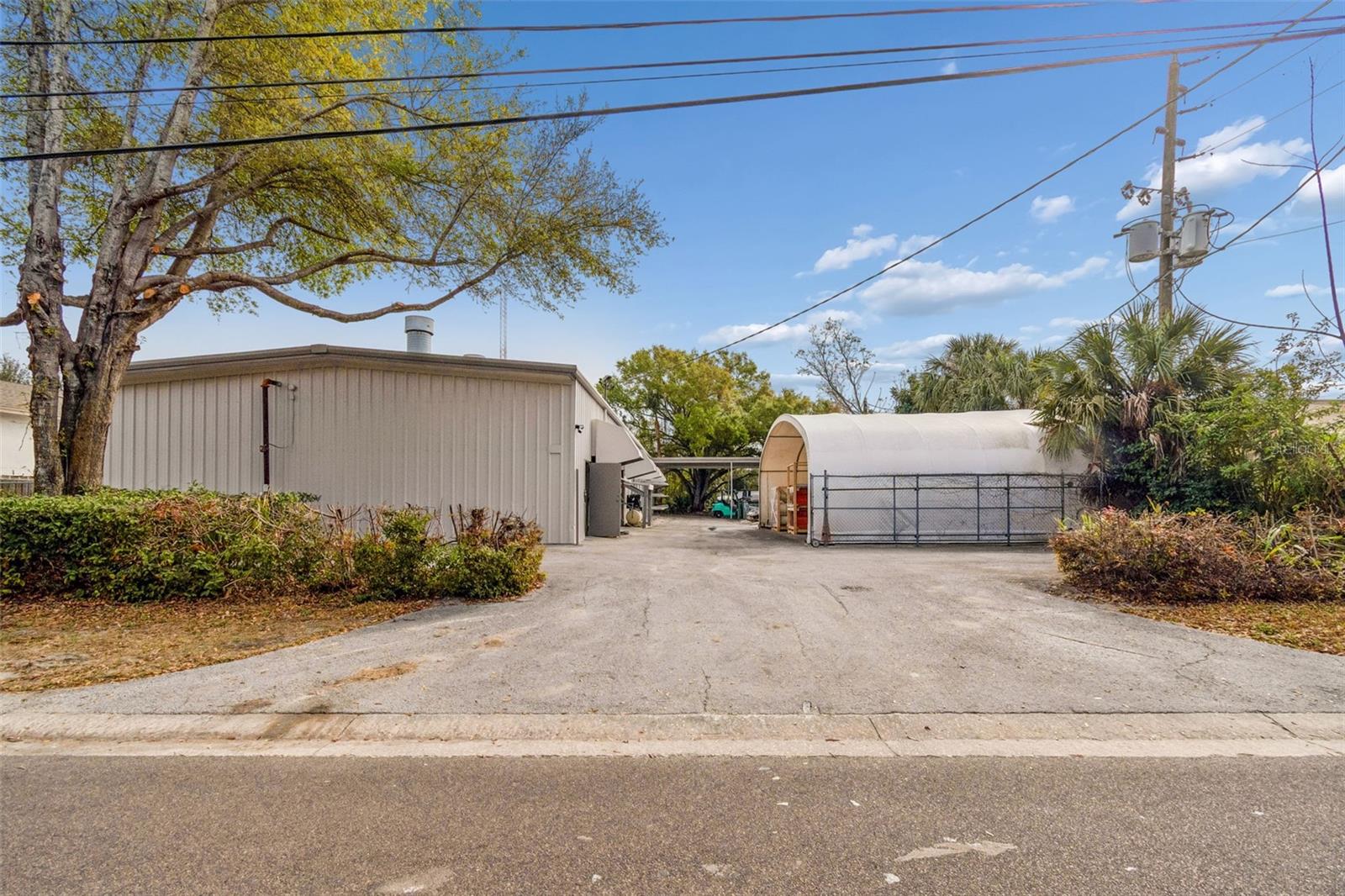 We are pleased to present 1060 Harbor Lake Drive, Safety Harbor, FL 34695 (the “Property”). This is a rare opportunity to acquire a freestanding industrial warehouse located within the highly desirable Harbor Lake Industrial Park in Safety Harbor. The Property consists of approximately 4,720 square feet (40’ x 118’) of pre-engineered metal construction built in 1985. Constructed with steel truss and purlin roof framing, slab-on-grade foundation, spread/monolithic footings, and corrugated metal roofing, the building offers durable, functional industrial design suited for long-term operational use. The building is all warehouse space with no built-out office area, aside from a single restroom, allowing for maximum usable square footage and operational flexibility. The open-span interior provides an efficient layout ideal for fabrication, manufacturing, storage, or contractor-based businesses that prioritize production space over administrative build-out.
The warehouse features two 14-foot grade-level roll-up doors, 16-foot clear heights, and robust electrical service including two panels: one 150-amp panel and one 250-amp, 3-phase panel. The building is equipped with a substantial mechanical ventilation system consisting of three 10 HP, 36-inch Hartzell ceiling exhaust fans with interior air plenum distribution, along with five 3 HP, 36-inch Hartzell intake fans positioned along the south wall. This system provides significant airflow capacity for operations requiring heat dissipation, air exchange, or industrial ventilation. The property includes a wide concrete apron for parking, loading, and maneuverability, along with additional exterior area suitable for equipment staging or material storage. Located within a stable industrial park environment with limited turnover, buildings of this size and functionality in Safety Harbor are increasingly difficult to find. For owner-users seeking efficient industrial space with strong fundamentals and upgraded mechanical infrastructure, 1060 Harbor Lake Drive represents a practical opportunity in one of Pinellas County’s most supply-constrained submarkets.