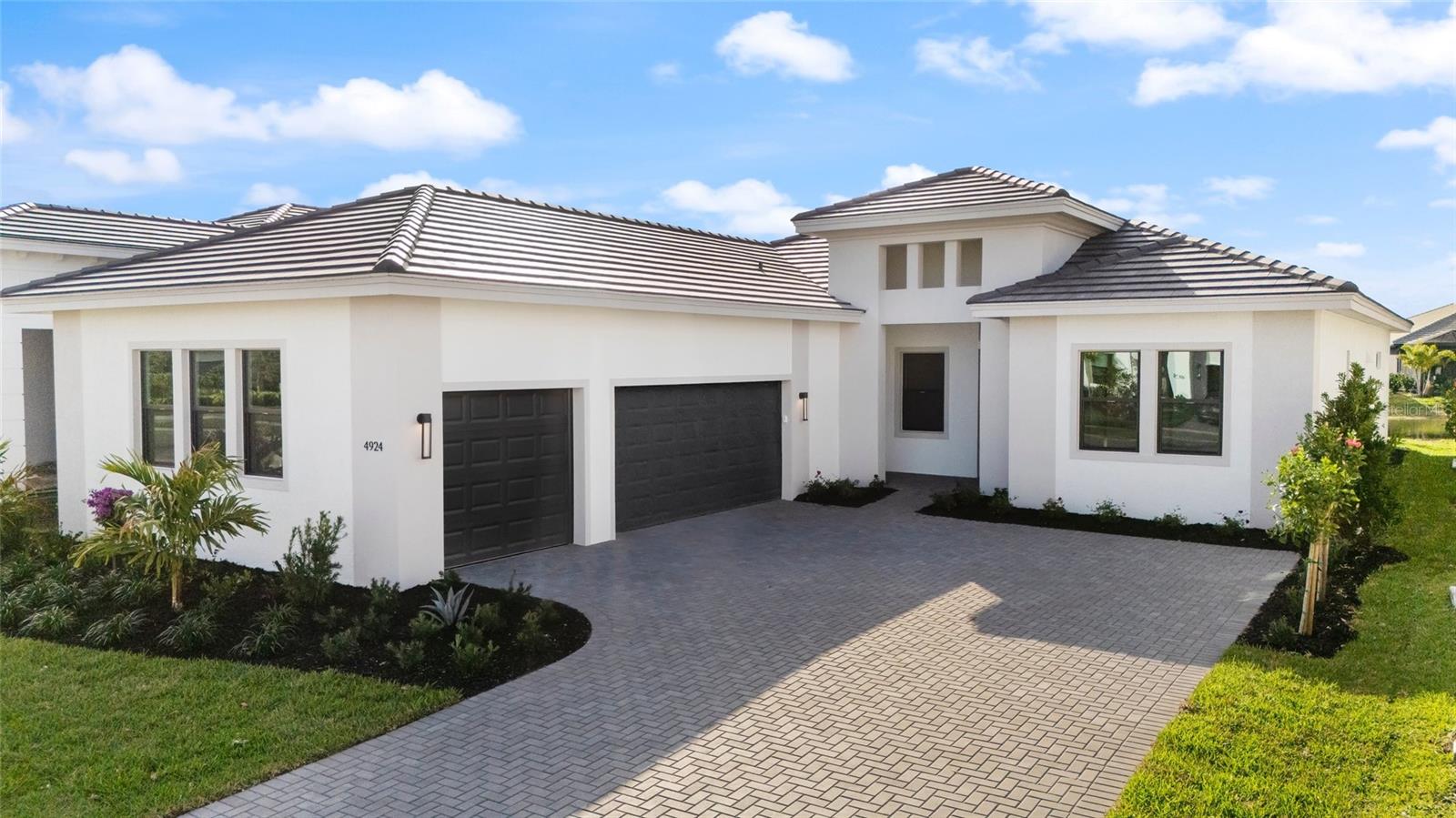 Step into effortless luxury with this stunning move-in ready 3 bedroom, 3.5 bath + Den home, thoughtfully designed with both style and comfort in mind. At the heart of the home, a chef-inspired kitchen showcases an oversized center island with a sleek waterfall edge, complemented by elegant two-tone cabinetry featuring soft-close doors and drawers. Premium Cambria quartz countertops, a full wall designer backsplash, a 36” gas cooktop, and a striking wall-mount canopy chimney hood create a space that is as functional as it is beautiful. Natural light fills the home through impact glass windows and doors, enhancing both energy efficiency and peace of mind. Each bedroom offers its own private ensuite bathroom, while a separate powder bath provides added convenience for guests. Step outside to the extended covered lanai with a privacy wall—perfect for relaxing or entertaining—overlooking a serene waterview homesite. The home is also prepped for your future outdoor dreams, with space ready for a summer kitchen and pool. Additional highlights include a spacious 3-car garage with epoxy flooring and open cell spray foam insulation for improved comfort and efficiency year-round. This home blends modern design, thoughtful upgrades, and future-ready features—making it truly move-in ready and waiting for you. Cresswind Lakewood Ranch by Kolter Homes is an exclusive gated community in Lakewood Ranch, Florida, designed for active adults seeking new energy-efficient homes and low-maintenance living. Residents enjoy a pet-friendly environment, scenic walkways, and access to a private lakeside clubhouse with organized activities, flexible event spaces, fitness and yoga studios, and creative art facilities. Outdoor amenities include pickleball, tennis, bocce, resort-style pools, a dog park, food truck court, and social areas. Located in Sarasota/Bradenton, the community offers proximity to beaches, shopping, dining, and cultural attractions, making it an ideal choice for those searching for vibrant, resort-style living on Florida’s Cultural Coast.