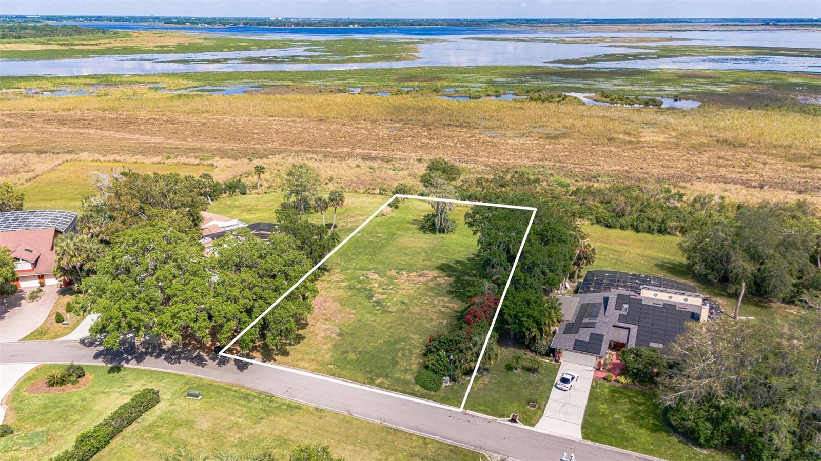 LAKEFRONT LOT in GATED NEIGHBORHOOD of HIDDEN HARBOR * 0.52 ACRES * PICK YOUR OWN BUILDER * BUILD ON YOUR TIMELINE * TENNIS COURTS, GAZEBO, BASEBALL DIAMOND and a FISHING PIER OVERLOOKING the NEIGHBORHOOD POND. Last available buildable LAKEFRONT lot in the EXCLUSIVE, GATED Hidden Harbor community, nestled on the stunning shores of Lake Toho, part of the renowned Chain of Lakes. This 0.52-acre cleared lot is ready for your dream home, offering sunrise views, lush oak trees, and a serene, private setting with no building time restrictions—pick your own builder! Enjoy resort-style amenities including tennis courts, a pond, fishing pier, and secrity gate, all within an established, low-HOA neighborhood. Ideal for both investment or personal use, this prime location is just minutes from NEO CITY AND NEO CITY ACADEMY, DOWNTOWN KISSIMMEE, popular travel destinations, shopping, restaurants & much more. With access to top bass fishing lakes and the ability to boat to the coast, this is an opportunity you won’t want to miss!