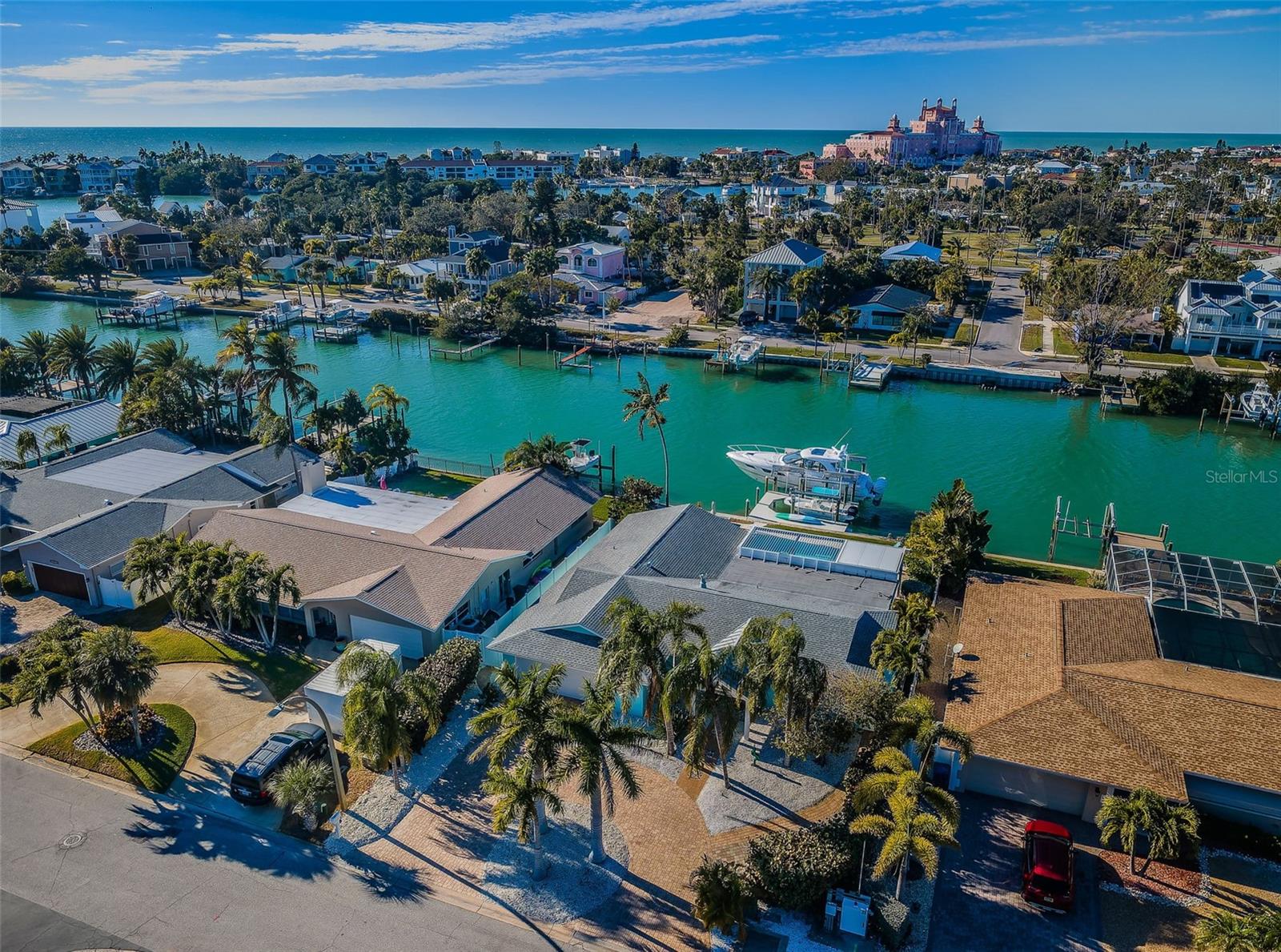 Completely remodeled and updated down to the studs in 2021. Very little water on property from Hurricane Helene and no water damage in any of the living areas from the storm. This exceptional 5 bedroom, 3 bath home has been beautifully renovated for the large or growing family who loves the waterfront lifestyle. Well-landscaped with a sweeping circular pavered driveway, you’ll feel welcomed by the fine covered entryway that introduces this lovely residence. The sumptuous kitchen boasts dazzling quartz surfaces, coastal white cabinetry, Subzero refrigeration, hi-end gas cooking, stainless steel farmhouse sink, ample storage and much more. Complementing the kitchen is a wonderful casual dining island/bar (matches the kitchen with built-in power) that overlooks the pool deck and waterfront. Your sizable living area offers a splendid contemporary dry bar (matches kitchen) with beverage/wine chiller. The owner’s suite enjoys a generous, dedicated waterfront sitting area and a sizable walk-in closet with closet system. Owner’s bath features dual vanities, a built-in Kohler soaking tub, and a richly-tile walk-in glass shower enclosure. The guest bedroom suite was new with the remodel, serves as a second master in size, and contains a superb bath with luxury vanity and gorgeous glass shower enclosure. Bedrooms 3, 4 and 5 are situated on the other side of the floor plan from the master suite and guest master suite. Two of the three overlook the waterfront and all three are supported by an elegant guest bath with attractive dual vanities and alluring glass enclosed shower with exquisite tilework. This bathroom also has separate access to the pool deck through an outer door. The main living area has a series of French doors which open to an expansive 450 square foot covered living area with room for both outdoor dining and couch/lounging area, all overlooking the swimming pool/waterfront – with beautiful sunsets and direct views of the Don CeSar. Back yard area is landscaped for privacy on both sides. Supporting an outdoor gas cooking center and contemporary gas firepit, the expansive paver pool deck was fully redone in early 2025. The home features a substantial swimming pool which was resurfaced during the 2021 remodel. The centerpiece of the outdoor living space is a four year old composite wrap-around dock, with shore power, water and two boat lifts; a 40,000lb boat lift and a separate 13,000lb boat lift provide rapid, easy access to the intracoastal waterway and the Gulf. From your backyard slip, cruising time to the Pass-A-Grille Pass is under ten minutes. The backyard marina enables one to keep both a large vessel (owners have kept a 41 foot Intrepid there for the past four years) and an island/bar hopping vessel at the same time. The home is situated in a corner end of Vina Del Mar, heightening privacy and safety, and minimizing traffic, yet offering a 25-minute walk or 5-minute golf cart ride to the center of Pass-A-Grille beach life. This is a wonderful waterfront home, and terrific value located in the heart of Vina Del Mar. Measurements are estimates, buyer to verify.