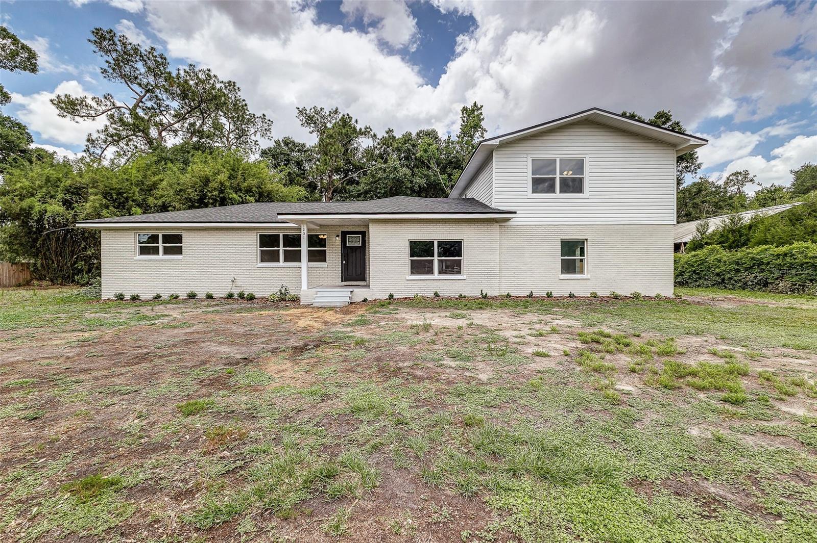 Tucked away on over one and a half acres in North Lakeland, this newly renovated 2-story home sits on 1.51 cleared acres with mature shade trees, offering the perfect blend of upgrades, charm, and space to spread out. Nearly every major component has been updated for peace of mind, including a new roof, new A/C system, new windows, updated electrical, re-piped plumbing, new electric water heater, and a brand-new septic tank and drain field.
Inside, you’ll find spacious living areas featuring brand new luxury vinyl plank flooring, including a cozy wood-paneled room full of warmth and character. The completely remodeled kitchen shines with granite countertops, stainless steel appliances, brand new cabinetry, and plenty of space for a kitchen island or breakfast nook. Just off the kitchen is an oversized laundry room that’s conveniently close while remaining tucked out of the way.
Character details throughout the home include built-in shelving and a nostalgic old-school phone nook that adds charm and endless possibilities for modern use. All bedrooms have been updated with brand new carpet and ceiling fans, while the expansive upstairs primary suite is a true retreat offering privacy and a spacious ensuite bathroom with a dual sink vanity.
Step outside and enjoy the peaceful surroundings from the covered second-floor porch overlooking the property, or relax on the covered front and rear porches. The exterior also features a 2-car carport, two detached pole barns, wood and wire fencing, and a beautifully cleared lot with plenty of room for hobbies, animals, equipment, or future additions.
With extensive renovations already completed and room to enjoy country-style living while staying close to Lakeland conveniences, this move-in ready property is a rare find. USDA FINANCING AVAILABLE FOR ELIGIBLE BUYERS, WITH NO MONEY DOWN. CALL TODAY FOR MORE DETAILS.