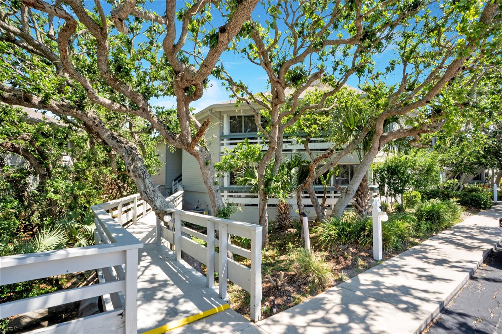 Welcome to THE VERANDAS AT SEA WOODS. You won’t find another BEACHSIDE COMMUNITY that matches this combination of natural beauty and incredible amenities with 3 access paths to the NO-DRIVE BEACH. This rarely offered, updated 2 bed/2 bath, 2nd floor unit includes a finished 250 sq ft UPSTAIRS LOFT that could EASILY be converted to a 3RD BEDROOM.  So many wonderful updates as well including the beautiful matching custom cabinetry in kitchen and primary bath, new interior paint throughout(2024), new hurricane impact windows(2024) and recently replaced HVAC(2023) with transferable labor warranty.  You will love lounging on the oversized screened patio which is accessed by both bedrooms and the main living area. These very spacious 2nd floor units have a genuine "treehouse" feel and receive welcome shade in the Summer months from the canopy of beautiful oaks so prevalent throughout Sea Woods. Just grab your flip flops and beach gear because this home is being sold FULLY FURNISHED.  SEA WOODS is also a PET FRIENDLY community that allows SHORT TERM RENTALS for those seeking a great investment opportunity.  And what an incredible location - just a very short walk to the beautiful no-drive beach as well as several shopping and dining options and all of the community's wonderful amenities. Sea Woods features 3 pools(1 heated seasonally), tennis courts, shuffleboard, pickleball, a large clubhouse, updated fitness center and walking/biking/jogging paths canopied by sprawling oaks and surrounded by lush tropical landscaping. There's truly no other community like this beachside. Come see for yourself why SEA WOODS is still one of the best kept secrets in New Smyrna Beach.