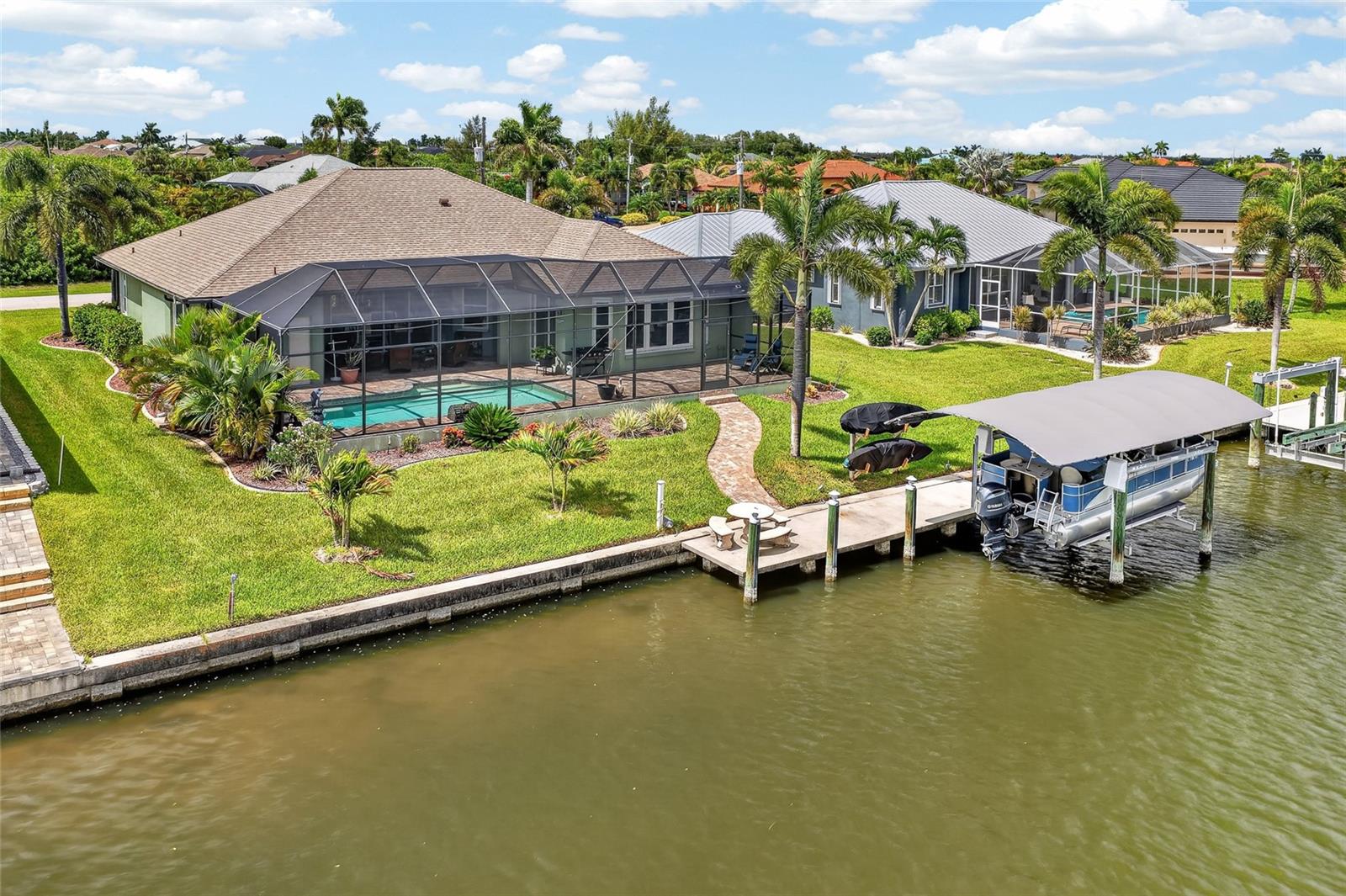 WATERFRONT LIVING AT ITS FINEST IN SOUTH GULF COVE! Welcome to this beautifully updated 3 BEDROOM, 2.5 BATHROOM, 2 CAR GARAGE POOL HOME offering the perfect combination of luxury, comfort, and boating convenience. Situated on a navigable canal with a private dock and boat lift, this MOVE-IN READY residence is just a short boat ride from open water, making it an exceptional opportunity for boaters and waterfront enthusiasts alike.

From the moment you arrive, you’ll appreciate the care and attention that has gone into this home. Extensively REMODELED IN 2023, the property showcases elegant finishes, stylish décor, and thoughtful updates throughout. Inside, soaring HIGH CEILINGS, beautiful flooring, and an open, airy layout create a welcoming atmosphere that feels both spacious and refined.

The kitchen serves as the heart of the home and features QUARTZ COUNTERTOPS, STAINLESS STEEL APPLIANCES, ample cabinetry, and a layout designed for both everyday living and entertaining. The home’s desirable SPLIT FLOOR PLAN provides privacy for both owners and guests, while the spacious living and dining areas flow seamlessly together.

The oversized primary suite offers a true retreat, featuring generous proportions and a large ensuite bathroom designed for comfort and relaxation. Two additional guest bedrooms provide comfortable accommodations for family and visitors.

Step outside and discover your own private Florida paradise. The screened lanai and pool area offer plenty of room for entertaining, relaxing, and enjoying the waterfront lifestyle. A convenient POOL BATHROOM located directly off the lanai eliminates the need for wet feet throughout the home and adds functionality to the outdoor living space.

Boating enthusiasts will appreciate the private dock equipped with a 6,000-POUND BOAT LIFT WITH CANOPY, allowing for quick and easy access to some of Southwest Florida’s best boating, fishing, and waterfront destinations. Additional exterior features include a BUILT-IN STORAGE SHED integrated into the side of the home, providing valuable space for tools, equipment, and outdoor gear.

For added peace of mind, the property features a NEW ROOF INSTALLED IN 2022, as well as a combination of IMPACT-RESISTANT WINDOWS AND HURRICANE PROTECTION PANELS designed to help protect your investment.

Whether you’re searching for a year-round residence, seasonal retreat, or waterfront getaway, this exceptional home checks all the boxes. Combining modern updates, elegant design, boating access, and a prime South Gulf Cove location, this is Florida living at its very best.

DON’T MISS YOUR OPPORTUNITY TO OWN THIS BEAUTIFULLY REMODELED WATERFRONT POOL HOME WITH DIRECT BOATING ACCESS TO OPEN WATER!