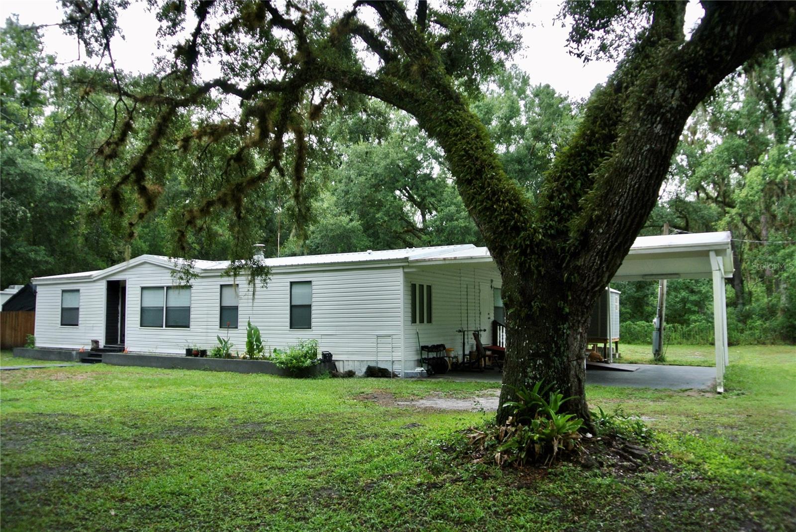 Welcome to this beautifully updated and exceptionally well-maintained 3-bedroom, 2-bath manufactured home with no HOA or deed restrictions. The spacious kitchen features elegant quartz countertops, perfect for preparing meals and entertaining. Situated on approximately half an acre of fenced land, the property provides ample room for your RV, boat, trailer, recreational vehicles, and outdoor equipment. RV sewer and electrical hookups are already available. Additional improvements include a new air-conditioning system installed in 2025 and a durable metal roof replaced in 2020. The oversized carport and generous outdoor space are ideal for entertaining, gardening, or enjoying the Florida lifestyle. Schedule your private showing today! Se habla español.