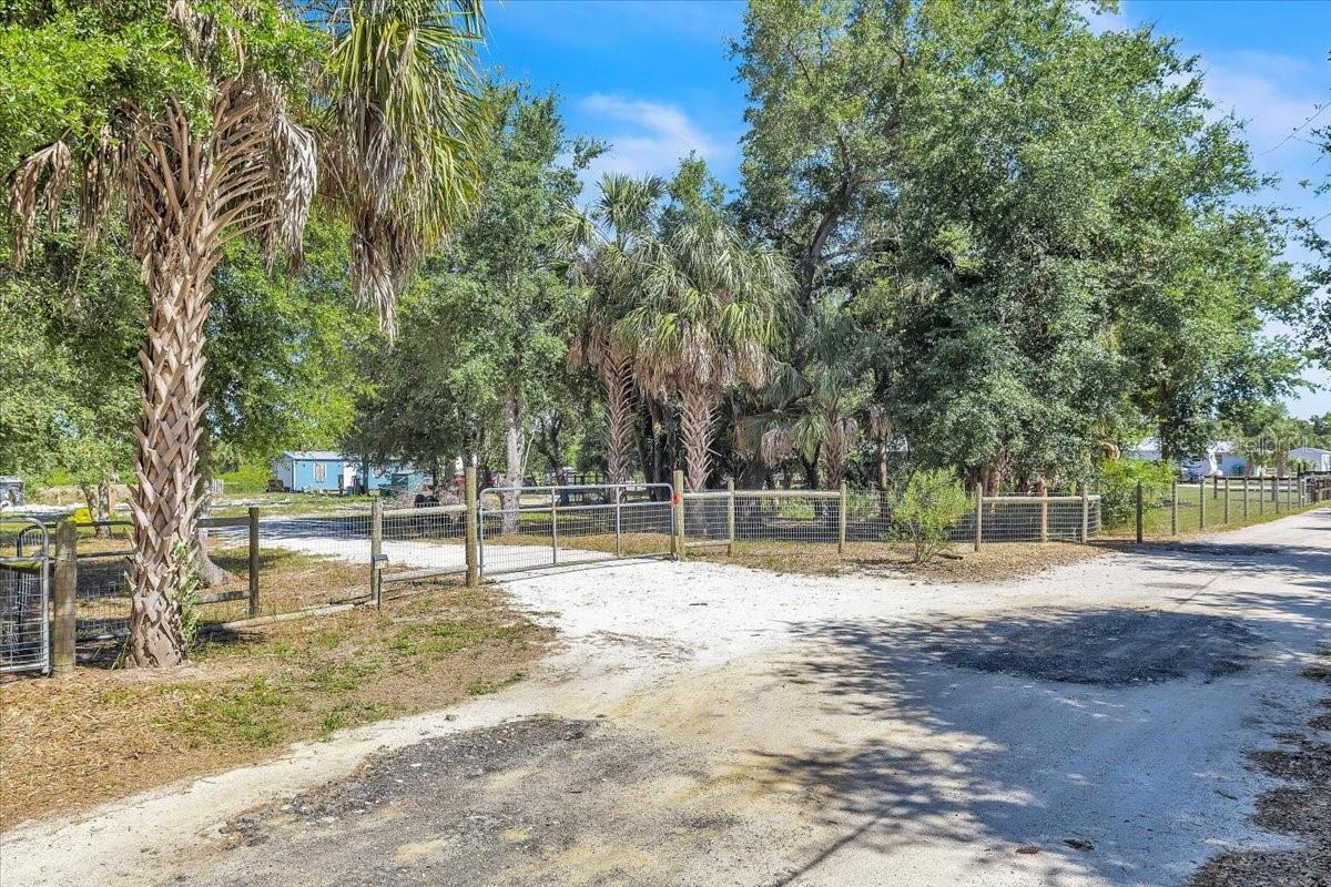 Discover the perfect blend of privacy, rural charm, and opportunity with this exceptional 1.25-acre property located in the desirable Charlotte Ranchettes area of Punta Gorda. This gated and fully fenced parcel offers a peaceful country setting with existing water, septic, and electricity already in place, providing added convenience and a head start for your future plans. Previously improved with a mobile home that has since been removed, the property is well-positioned for a new homesite, manufactured home, or future development opportunity. Zoned Agricultural (AG), allowing one residential unit per 10 acres, the property offers flexibility for agricultural use, horses, livestock, workshops, RVs, boats, and more. A versatile addition to the property is the spacious storage building with roll-up garage door access, ideal for equipment, tools, workshop space, or recreational storage. The property also includes temporary setup for an RV with utilities already connected, offering excellent functionality and convenience for temporary living, travel accommodations, or while planning your future build. Surrounded by open space and mature greenery, this property provides the perfect blend of rural living, privacy, and versatility while still being conveniently located near Punta Gorda amenities, shopping, dining, and I-75 access.