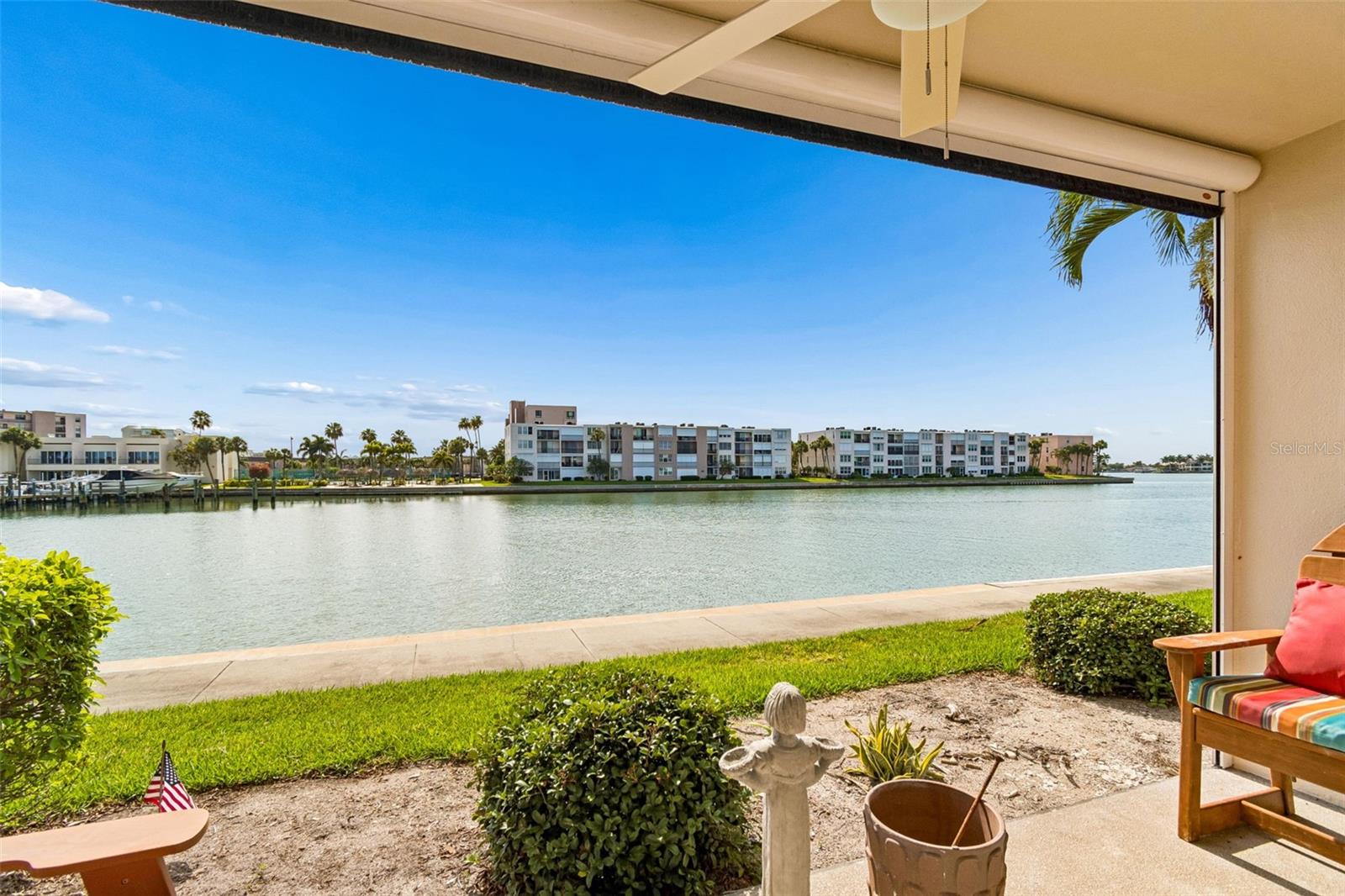 Welcome to your pristine coastal sanctuary. Designed with a "coastal chic" aesthetic, this professionally remodeled 2-bedroom, 2-bathroom residence offers 1,110 sq. ft. of sophisticated, light-filled living space. Located in Bay Island, a premier 24-hour gated 55+ community, this turnkey end unit, pairs waterfront views with added piece of mind — a brand-new building roof (December 2025) to protect your investment and ease special assessment worries. Step inside to an airy, open layout highlighted by premium ceramic tile flooring and zero carpet. The gourmet kitchen is a chef’s delight, thoughtfully designed with gleaming granite countertops and a pass-through breakfast bar that keeps the water views in sight, brand-new stainless-steel appliances and custom shaker-style cabinetry featuring soft-close hinges, durable dovetail drawers, and convenient pull-out shelving — topped with crown molding. The generous primary suite serves as a private retreat, offering peaceful water views, a large walk-in closet with custom built-in shelving, and a luxurious ensuite bathroom. Pamper yourself in the spa-like walk-in shower with floor-to-ceiling tile work, complemented by a new granite-topped vanity. For ultimate convenience, a dedicated in-unit washer and dryer are housed right here. Guests will feel equally spoiled in the fully renovated second bathroom, showcasing an elegant tile inlay in the tub/shower combo. Blissful Florida evenings await on your private, covered lanai. Unwind against a backdrop of peaceful sunset views, made even better by a premium upgrade: an electronic roll-down, high-visibility screen that protects your space without ever obstructing your view of the water. Additional high-value features include full impact-resistant windows and sliding door, a brand-new water heater, and a dedicated covered parking space. In Bay Island, you’ll enjoy a vibrant, maintenance-free lifestyle. Exceptional amenities include heated pools and spas, tiki huts, waterfront grilling stations, tennis, pickleball, shuffleboard courts, and a waterfront walking path. The clubhouse has a fitness center, billiards, and a robust social calendar. The all-inclusive monthly fee covers: Basic cable, high-speed internet, water, sewer, trash, flood insurance, exterior landscaping, and 24-hour security. The community is pet-friendly (up to 2 pets, 1 dog max under 15 pounds) and allows flexible rentals (30-day minimum, 3x per year). Ditch the hassle of parking when enjoying the area, because a SunRunner rapid transit stop sits right outside the community gates, whisking you away to world-class Gulf beaches, local shopping dining, or vibrant downtown St. Petersburg in minutes. Don't just buy a condo—upgrade your lifestyle. Schedule your private tour today!