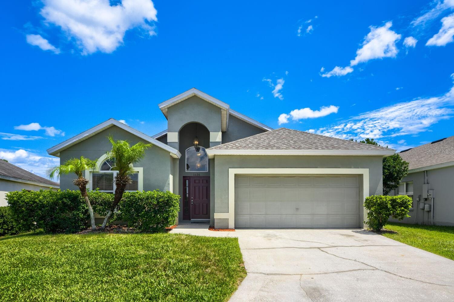 Stunning 4 bedroom / 3 bath home in PRIME LOCATION with convenient access to Disney World and world-class golf courses, featuring $50,000 in recent updates and improvements! Whether you’re looking for a PRIMARY RESIDENCE for your family, a SECOND HOME for winter/vacation stays, or an income-producing RENTAL PROPERTY, this well-maintained home checks all the boxes. BRAND NEW WOOD-LOOK TILE FLOORING (2026), NEW ROOF (2024), NEW screen enclosure (2026), BRAND NEW oven, microwave and dishwasher (2026), newer hot water heater (2022) and newer AC (2020/2022) -- all provide peace of mind for the new owners. FRESH PAINT inside (2026) and NO CARPET make it move-in ready… and easy to maintain. Vaulted ceilings and natural light give the home an open and airy feel. The kitchen offers abundant cabinets and countertop space as well as a generous pantry. The breakfast bar and adjacent seating area provide flexibility for casual meals, while the separate living and dining areas provide more space for large gatherings and entertaining. OR, possibly convert the living room into a HOME OFFICE or PLAYROOM. There’s also a spacious family room, offering even more options to fit your needs. The split-bedroom layout with 3 full baths is ideal for families – while also providing privacy when hosting guests. The spacious primary bedroom offers a separate exit onto the screened patio and features dual sinks, a soaker-tub and separate shower in the bathroom. Extra closets and storage space as well as an included washer and dryer round out some of the home’s many incredible features. The LOW HOA includes a community clubhouse with FITNESS EQUIPMENT, as well as a tennis / pickleball court. All in a location that offers easy access to major highways (I-4 and Hwy 27) and area attractions, renowned golf courses, dining and retail shopping options, grocery stores, and more. Don’t let this one pass you by – schedule your showing today!