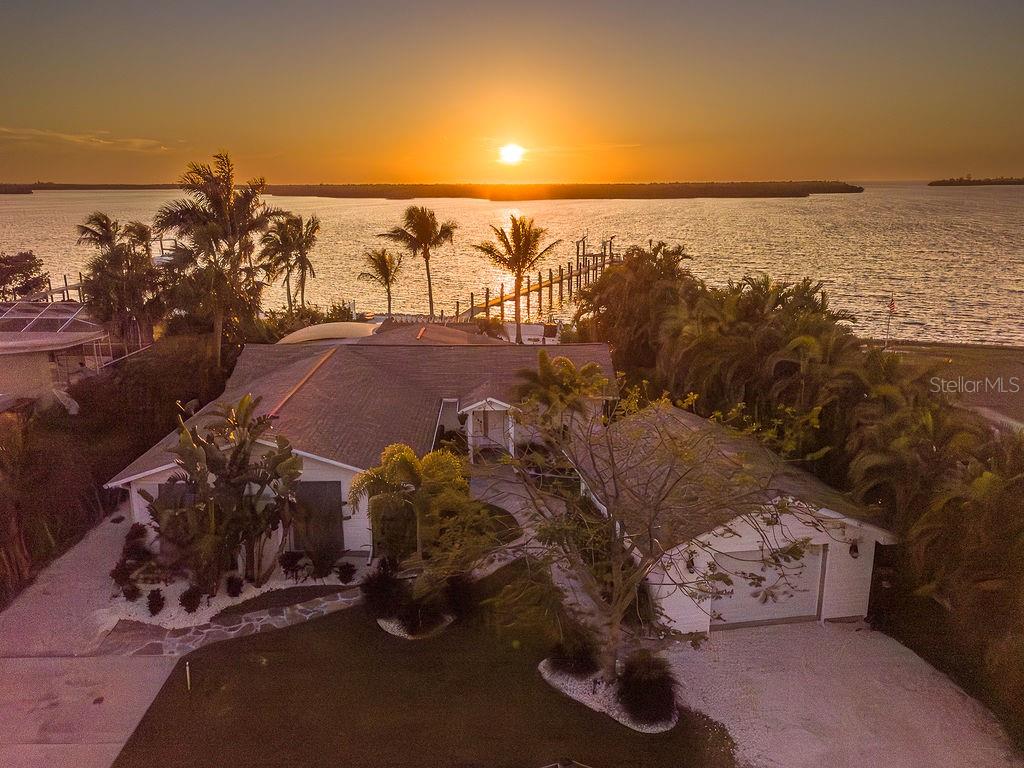 Welcome to a modern coastal paradise, hidden on idyllic Terra Ceia Island! Over a quarter acre along the aquatic preserve of Miguel Bay, this home offers endless entertainment with an open floor plan and fully updated modern aesthetic, surrounded by a tropical setting, fiery sunsets, and views of the Skyway Bridge. The property doubles as a wonderful investment opportunity with no HOA or leasing restrictions, providing not just a short-term rental or AirBnB but a true Old Florida experience, where Captains bring their charters for World Class inshore fishing, only a few minutes to Gulf waters. A 165-foot dock on open water, built with durable Trex decking, comes equipped with water, power, boat lift with remote, and stairs leading down for an easy kayak launch with no rear neighbors and a view of tranquil mangrove islands.
Relaxation awaits in this 4-bedroom, 2.5 bath beautifully updated custom coastal residence, intended to complement its serene surroundings with water views from nearly every room. The thoughtfully designed split floor plan offers privacy and flexibility with a master suite featuring a discrete entrance off the lush courtyard with multiple cedar closets & custom built-ins. The second bedroom boasts an ensuite with a bathtub creating a welcoming space for any guest. The third bedroom features a private covered patio. The fourth bedroom, currently utilized as a nursery, could easily serve as a home office or hobby room. Each bathroom has been carefully updated with custom vanities and travertine tile. A bonus room which could serve as a 5th bedroom, currently features laundry and an icemaker, offering easy storage and accessibility for the fisherman on the go!
Warm wood-beamed ceilings, elegant Leonardo Travertine in Versailles pattern, Sunset quartz countertops, in a central, open kitchen, create an inviting, sophisticated atmosphere. The fully updated Chef’s kitchen is the heart of the home, with an oversized island, seamlessly connects the family room with the outdoors, all overlooking Miguel Bay. Samsung Bespoke White Glass Kitchen Suite of appliances offer state of the art features.
Venture out of the luxurious interior into one of the many outdoor living areas, and enjoy stargazing in the tropical courtyard or cocktails fireside after a long day of boating. You will be greeted by all that nature has to offer, from Manatees, dolphins, tarpon, white pelicans, and roseate spoonbills. The meticulous grounds feature winding stone paths under the canopy of a Royal Poinciana, “The Lido Deck” pergola, charming shell beach under swaying Coconut, Bottle, Areca Palms, all surrounded by mature Florida landscaping.
For those fortunate enough to enjoy, historic Terra Ceia Island is more than just a location—it's a lifestyle. This close-knit active community comes together for events like the Mullet Festival, Kayak Poker Regatta, Halloween Hayrides, Around the World Dinner, Easter Egg Hunt, and a Christmas Golf Cart Parade. The optional Village Improvement Association provides access to the community hall and waterfront Seabreeze Park, complete with picnic pavilions, boat ramp, a soon to be built 300 ft fishing pier, playground & pickleball courts. Conveniently situated at the foot of the Sunshine Skyway Bridge, Terra Ceia offers easy commute and access to St. Pete Beach, Tampa, Anna Maria Island, and Bradenton. Unwind and experience Old Florida living at this one-of-a-kind luxury waterfront property.
