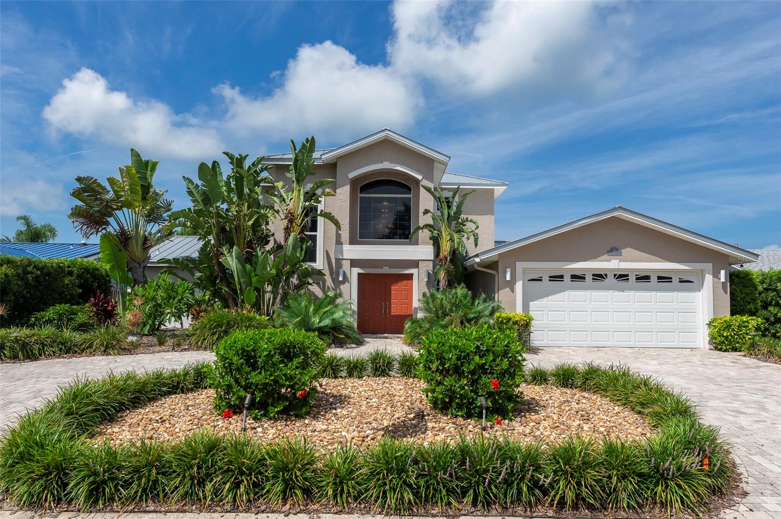 Welcome to your private waterfront retreat on the island of Vina del Mar, located at the southern tip of St. Pete Beach! This exceptional 2-story home offers the ultimate Florida lifestyle with a beautifully landscaped backyard oasis overlooking a wide, protected canal with direct Gulf access.  Designed for both relaxation and entertaining, the outdoor space features a covered patio, heated saltwater pool, hot tub with pergola, newer composite dock with boat slip, and well-planned spaces to enjoy sunny days and spectacular sunsets. This 2,980 sq ft residence was architecturally designed and renovated, featuring a spacious upper-level primary suite with a large bedroom, ensuite bath with Jacuzzi tub and recently renovated walk-in shower, a grand custom walk-in closet, and adjoining office/study.  French doors open to a private balcony overlooking the tranquil waterway. The elegant 2-story entry welcomes you into an open and inviting floor plan with beautiful views of the pool and canal from all the main living areas. The living room features French doors framing the outdoor scenery and a charming 2-sided propane fireplace that adds warmth and ambiance to both the living and family rooms. The family room offers a wet bar and is currently home to a tournament-sized Vintage Brunswick pool table.  The kitchen is enhanced with stylish cabinetry, granite countertops, wood flooring, and a large island with generous seating — a favorite gathering place for family and friends.  The first floor also includes two guest bedrooms, one with French doors opening to the hot tub area, along with two full baths.  Additional improvements include an eco-friendly metal roof installed in 2021, 1st floor AC (2021), & 2nd floor AC (2019). The oversized 2-car garage has been upgraded with a durable polyaspartic decorative floor coating and offers room for two vehicles plus a golf cart, along with a 240V outlet, two 120V outlets, and EV charging capability. Other features include surround sound wiring throughout the main living, pool, and garden areas; solar security film on windows; WiFi-enabled security system; whole-house water softener and filtration system; and an interior laundry room.  The front yard offers beautiful curb appeal with xeriscape landscaping and a pavered circular driveway.  The private backyard is enclosed by a gated vinyl fence and features lush tropical landscaping, a 16,000-gallon saltwater pool with electric heat/cool pump (2025), a standalone hot tub beneath an elegant pergola, and multiple thoughtfully designed spaces to relax, dine, sunbathe, and enjoy waterfront living.  Boater’s dream amenities include a composite dock and 16,000 lb boat lift replaced in 2021 with auto lift control, wrapped pilings, catwalk, electric, water, shower, and dock box.  The peaceful canal provides direct access to the Gulf with minimal boat traffic and no bridges.  Vina del Mar is one of St. Pete Beach’s most sought-after island communities, offering a true neighborhood feel just a short walk, golf cart ride, or bike ride to beautiful Pass-a-Grille Beach.The Vina del Mar Park features a pavilion with picnic tables, tennis and pickleball courts, playground, and dog park. When you leave the island, endless possibilities await — from white sandy beaches and Fort DeSoto Park to artsy downtown St. Pete with shopping, restaurants, galleries, museums, and more. Two Intl airports  within 30 minutes. The ultimate Florida lifestyle awaits at 311 S Isle Drive!