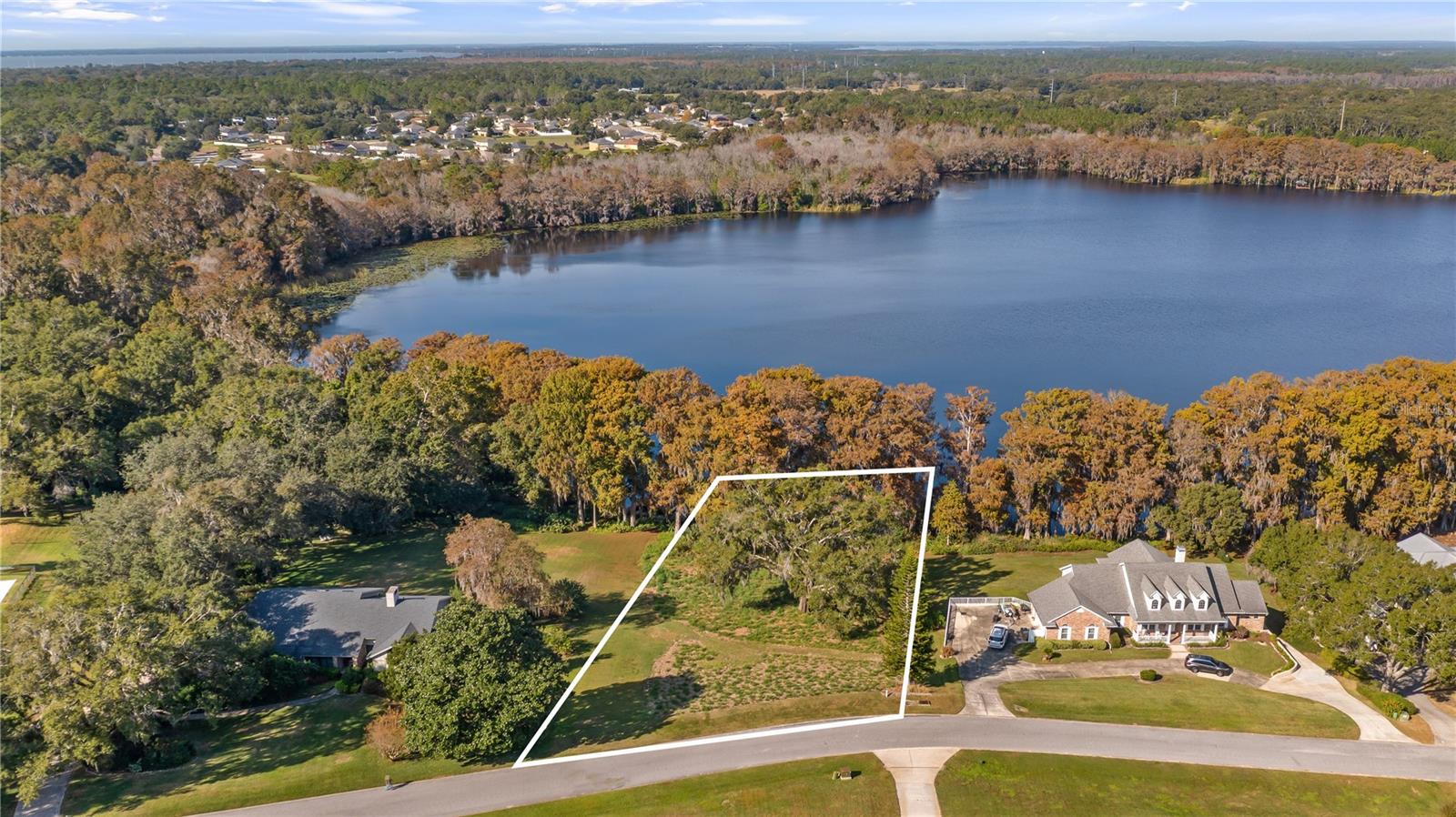 Your waterfront dream awaits. Picture yourself relaxing on your future homesite, perched high on a hillside overlooking the peaceful waters of Lake Swatara, where stunning sunsets paint the sky each evening. This amazing waterfront property offers over 1.27 acres of prime lakefront land with an impressive 180 feet of waterfrontage, beautifully framed by towering cypress trees that line the water's edge and create a picture-perfect setting for your custom dream home. Located in the desirable Lake Swatara Reserve community on a quiet cul-de-sac street, this exceptional vacant lot sits on the southern shore of a private 75-acre lake that's perfect for boating, fishing, and enjoying the Florida lakefront lifestyle. The elevated building site gives you fantastic lake views and plenty of privacy, surrounded by beautiful upscale homes that show the quality of this wonderful neighborhood. Best of all, there's no HOA, which means you choose your own builder and design the home that's perfect for you and your family. You'll love being part of Florida's Golden Triangle, where the charming towns of Eustis, Mount Dora, and Tavares come together to offer the best of lakefront living. Downtown Eustis is just minutes away with its scenic Lake Walk at Ferran Park, historic bandshell, and delightful vintage shops that give the town its warm, welcoming character. Mount Dora's famous antique shops, cozy bed and breakfasts, and popular Sunday brunch spots are also close by, along with all the new dining and entertainment options in Tavares. This private lake is ideal for recreation and relaxation, whether you enjoy kayaking, fishing, or simply watching the sunrise from your own backyard. The peaceful, secluded setting feels like a true getaway, yet you're only seven minutes from Highway 441, where you'll find all the shopping centers, restaurants, services, and banks you need for everyday convenience. Golf courses are nearby for weekend recreation, and the new 429 beltway makes getting around the Orlando area easier than ever. Even though you'll feel miles away from the hustle and bustle, you're actually perfectly positioned for exploring Central Florida. Orlando International Airport, Walt Disney World, Universal Studios, and all the theme parks are just 45 minutes to an hour away, making this location ideal whether you're commuting for work or planning weekend adventures with family and friends. The paved road and quiet cul-de-sac location add to the appeal of this special property, combining easy access with the privacy and tranquility you want in a lakefront homesite. This is a rare opportunity to own significant lake frontage in an established community where the lifestyle includes seaplane rides, waterfront living, and the natural beauty that makes this area so special. Start planning your custom build today on this beautiful piece of lakefront paradise where location, views, and opportunity come together perfectly.