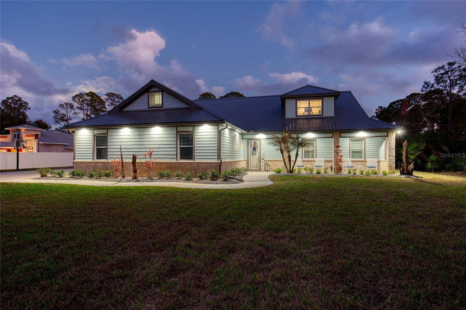 Welcome to 108 Pine Tree Drive, a stunning custom-built estate by Heritage Construction, perfectly positioned on 1.72 acres in one of the most desirable and centrally located areas of Ormond Beach. Offering 3,090 square feet of living space, this exceptional 4-bedroom, 4-bathroom, attached 3-car garage home blends refined craftsmanship, modern luxury, and resort-style outdoor living.

From the inviting front porch to the grand 8-foot entry doors, quality and attention to detail are immediately evident. Inside, the home showcases 10-foot ceilings, wood-look tile flooring throughout, and a built-in speaker system designed for seamless everyday living and entertaining. A striking in-home saltwater aquarium creates a one-of-a-kind focal point that sets this residence apart.

The luxury chef’s kitchen serves as the centerpiece of the home, thoughtfully designed for both beauty and function. Features include a premium KitchenAid stainless-steel appliance package with double ovens, electric range, and built-in ice machine. Custom 42-inch soft-close cabinetry, an oversized granite island with additional storage, and an exquisite glass backsplash are complemented by custom oyster chandeliers that elevate the space with coastal elegance.

The primary suite offers a true retreat, featuring a massive walk-in closet and a spa-inspired bathroom with dual marble vanities and abundant storage. Upstairs, a versatile fourth bedroom & bathroom, and a bonus room provide flexible living space, supported by a dedicated A/C system for optimal comfort.

Designed for unforgettable gatherings, the backyard is an entertainer’s dream. A covered 19 x 20 outdoor kitchen includes concrete countertops, grill, flat-top grill, stainless steel sink, refrigerator, and ice chest. The impressive 65 x 20 cabana with metal roof creates a private resort atmosphere complete with a wood-burning fireplace, outdoor TV, retractable shade panels, three ceiling fans, outdoor shower, and a custom 13-foot concrete table overlooking the heated saltwater pool. Expansive paved driveway completed in 2024, upgraded landscaping, and a large front lot enhance both functionality and curb appeal, while the property extends beyond the fenced area for additional space and flexibility.

In addition to the attached three-car garage, the property features a remarkable 70 x 50 insulated garage ideal for car collectors, RV owners, hobbyists, or multi-generational living. This versatile structure includes three 12' x 14' doors, one 12' x 10' door, and one 12' x 8' door, and is already plumbed for a future bathroom, offering exceptional potential for conversion into a detached guest house or true in-law suite.

Additional highlights include a saltwater-heated pool, brand-new metal roof on the home, 2022 kitchen appliance package, 2026 hot water heater, dual A/C systems installed in 2017 including a dedicated upper-level unit, 2025 water treatment system, and 2024 paved driveway. This one-of-a-kind property delivers the rare combination of luxury, land, and lifestyle in a private estate setting just minutes from shopping, dining, and beaches. All information recorded in the MLS is believed to be accurate but is not guaranteed. Buyers are advised to conduct their own due diligence to verify the information provided.