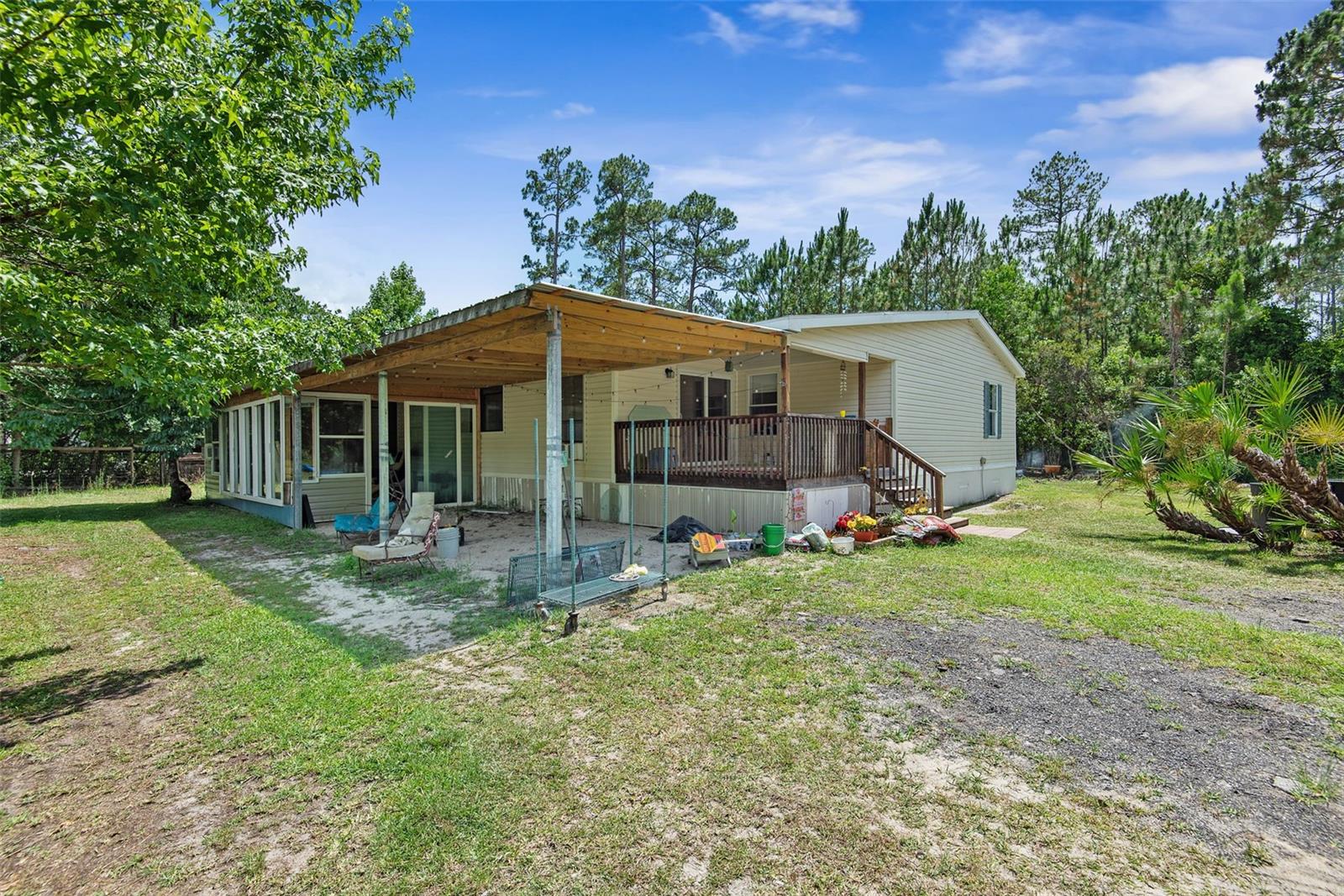 Enjoy the peace and privacy of country living while still being just a short drive to town, shopping, dining, and the beaches. Built in 2008, this spacious 3-bedroom, 2-bath manufactured home offers plenty of room to spread out with generously sized bedrooms, a large living room, dining area, bonus space, and an additional flex area perfect for a home office, hobby room, gym, or extra storage. Relax on the enclosed front porch and enjoy the convenience of the attached carport for shaded parking. Recent updates include brand-new skirting, new piping from the home to the well, a new water heater, and a walk-in jet tub in the primary bathroom. The pond has also been improved with a new pump system that helps direct excess water to the swale to assist with drainage. Situated on a large property with ample room for RVs, boats, trailers, and future additions such as a barn, garage, or workshop, this property is ideal for those seeking space and flexibility. Most farm animals are welcome, including horses and chickens, making this a great opportunity to enjoy a rural lifestyle with modern conveniences nearby.