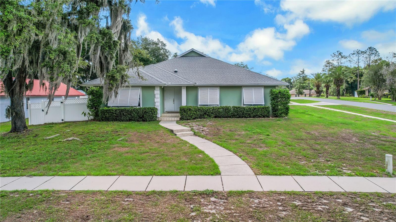 Welcome to this beautifully maintained 4 bedroom, 3 bathroom POOL home with a 2-car garage in Lady Lake. Step inside to discover tile and laminate flooring throughout.  The spacious kitchen features light wood cabinetry, tile backsplash, stainless steel appliances, a large closet pantry, and an oversized peninsula with breakfast bar seating. Open to the inviting family room with fireplace, this layout is perfect for everyday living and entertaining while offering beautiful views of the pool area. In addition to the family room, the home also offers a large living and dining room, giving you plenty of space to host family and friends. The screened lanai is ideal for relaxing outdoors, whether enjoying your morning coffee or spending the day by the sparkling swimming pool. Just outside the screened enclosure, you’ll find a low-maintenance artificial turf area perfect for outdoor games and gatherings. The white vinyl privacy fence creates the perfect backyard retreat. The primary suite features laminate flooring and a spacious en suite bathroom complete with a soaking tub/Jacuzzi, separate walk-in shower, and walk-in closet. The fourth bedroom also includes its own attached bathroom with a walk-in shower and built-in bench, making it ideal for guests or multigenerational living. Recent updates provide peace of mind, including a freshly painted interior (2026), new water heater (2023), West Shore Bahama storm shutters (2023), septic and drain field replacement (2022), solar tube installation in the foyer (2023), new pool pump with saline conversion (2022), roof replacement (2019), and HVAC replacement (2019). Conveniently located near shopping, dining, and The Villages, this home truly has it all!