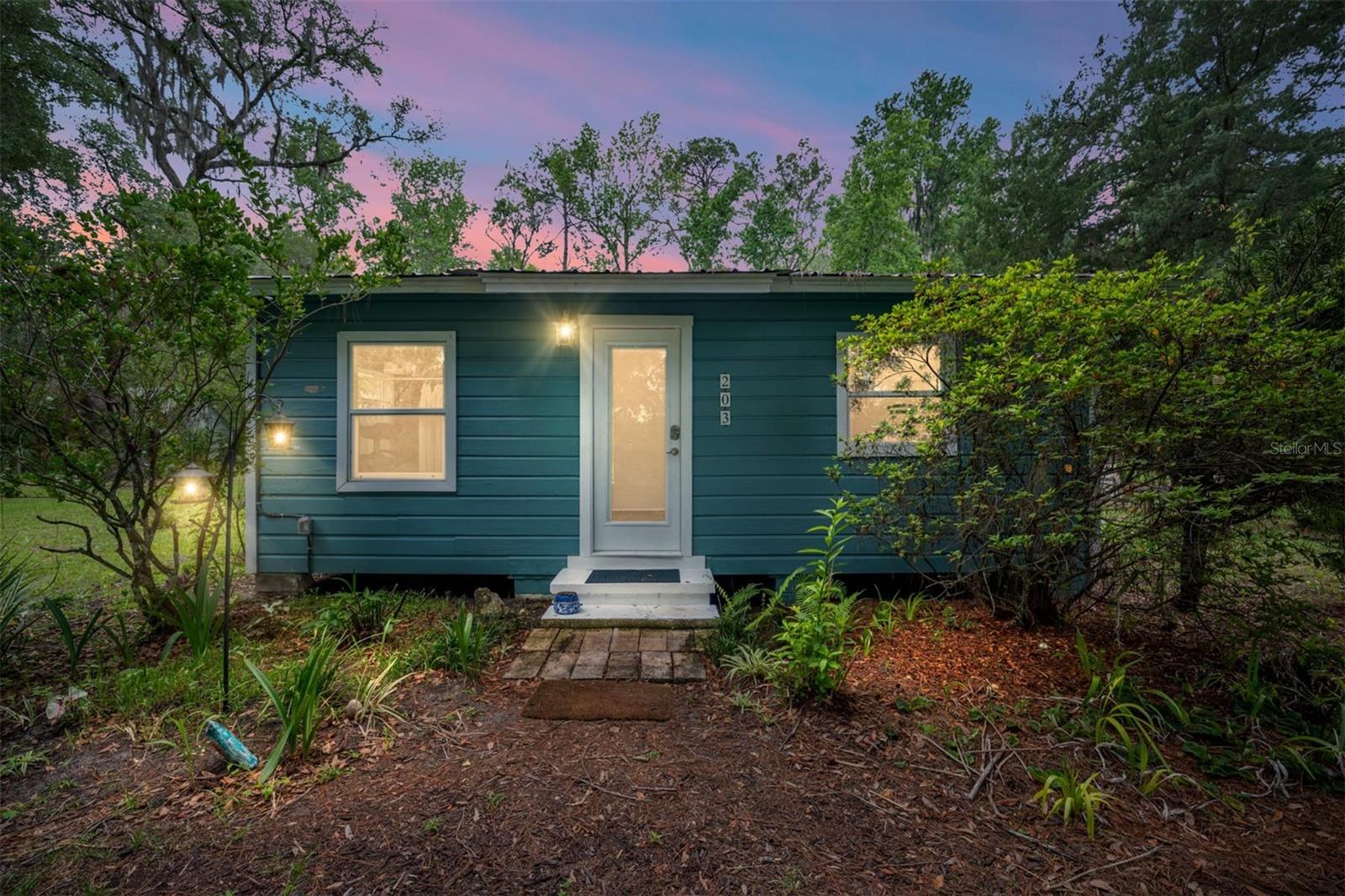 Don't miss this unique opportunity to live the gentle life of old Florida, where time slows to the rhythm of rustling palms and golden sunsets. Nestled on a peaceful acre beneath a canopy of live oaks, this property offers two restored bungalows—each with hardwood floors, hurricane-rated windows, metal roofs, and independent electricity, water, and septic. Cottage 201 (672 sq ft, 2 bedrooms) features a bright, open great room that combines the kitchen and dining area—ready for immediate occupancy or rental. Cottage 203 (620 sq ft, 1 bedroom) offers a charming kitchenette and an oversized 18x20 wood deck, already generating $950 monthly with a tenant in place. Steps from downtown, one mile from I-75, one block from 441, and an easy commute to UF, Shands, and Santa Fe. Live in one, rent the other, or hold both for maximum return—the choice is yours.