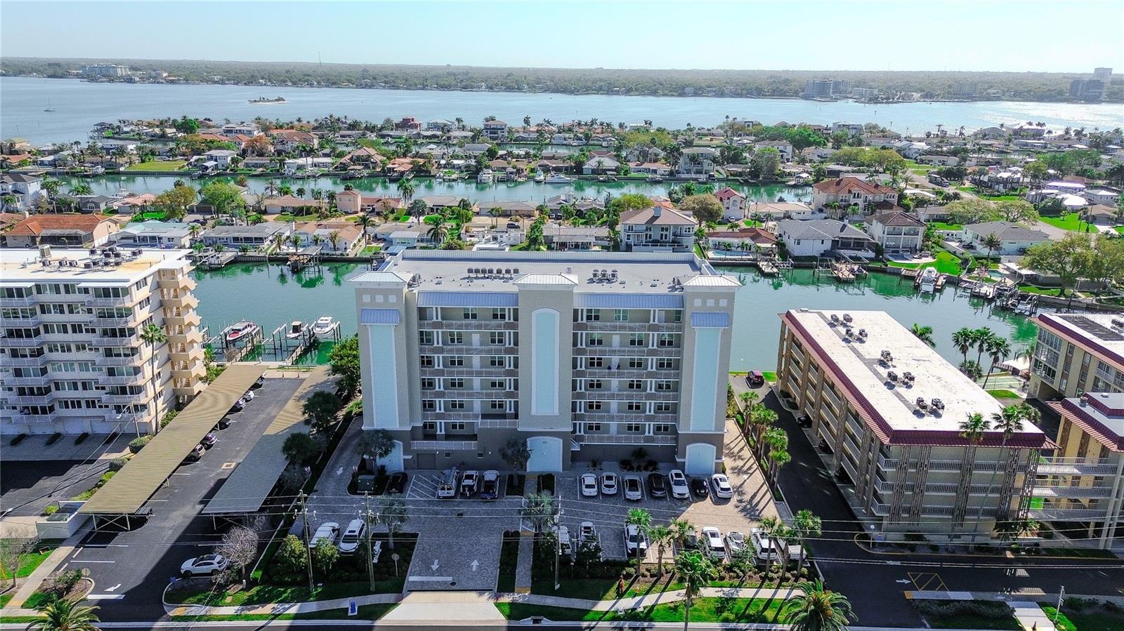 Welcome to Dolphin Harbour Condos, a stunning newer construction waterfront community built in 2023, ideally located in the heart of Clearwater Beach along the highly sought-after Island Way corridor. Known for its laid-back coastal atmosphere and breathtaking water views, Dolphin Harbour offers the perfect blend of peaceful island living while remaining just minutes from the famous powder sugar sands of Clearwater Beach. Perched high on the 5th floor, this beautifully designed and never lived in 3 bedroom, 2 bathroom condo offers nearly 1,800 square feet of living space and incredible views of the Intracoastal Waterway. Dedicated under building parking and additional deeded on site parking are yours to enjoy. Step inside to a spacious open layout where wood-look tile flooring flows throughout the main living areas and natural light pours in through floor-to-ceiling impact sliding glass doors that frame the water views. The impressive kitchen is truly the heart of the home, featuring quartz countertops, barstool seating space, stainless steel appliances, abundant cabinetry with undercabinet lighting, and a large pantry for additional storage. The kitchen opens seamlessly to the living area, creating the perfect space for both everyday living and entertaining. The owner’s suite is a private retreat, complete with a large walk-in closet and floor-to-ceiling impact sliders that provide direct access to the balcony. The ensuite bathroom features dual sinks, an oversized seamless glass shower, and a private water closet. A split bedroom floorplan offers added privacy, with the guest bedrooms positioned near a full guest bathroom. A full interior laundry room with additional storage adds everyday convenience. Step outside onto the expansive 30-foot balcony overlooking the Intracoastal Waterway, the perfect place to relax with your morning coffee or unwind while watching boats pass by. Additional highlights include two reserved parking spaces, including one under the building for added convenience. Dolphin Harbour offers residents amenities including a heated pool and spa located waterside. Just minutes away, the vibrant beachfront district offers waterfront dining, boutique shopping, and entertainment centered around Pier 60, famous for its nightly sunset celebrations, street performers, and local artisans. The Publix shopping plaza is just across the street! Outdoor enthusiasts will appreciate easy access to boating, paddleboarding, fishing, and nearby natural destinations such as Sand Key Park and Caladesi Island State Park, both known for their pristine beaches and scenic nature trails. Island Way is also home to the renowned Clearwater Marine Aquarium, a beloved local attraction dedicated to marine life rescue and rehabilitation. Despite its relaxed coastal vibe, the area remains highly convenient with quick access to downtown Clearwater, grocery stores, shopping, and a wide variety of waterfront restaurants just moments from your doorstep.  Whether enjoying sunset strolls along the beach, boating along the Intracoastal, or dining at nearby waterfront cafés, Dolphin Harbour offers a lifestyle that perfectly captures the charm and beauty of coastal living. Partial Seller Financing available.  Schedule your showing today!