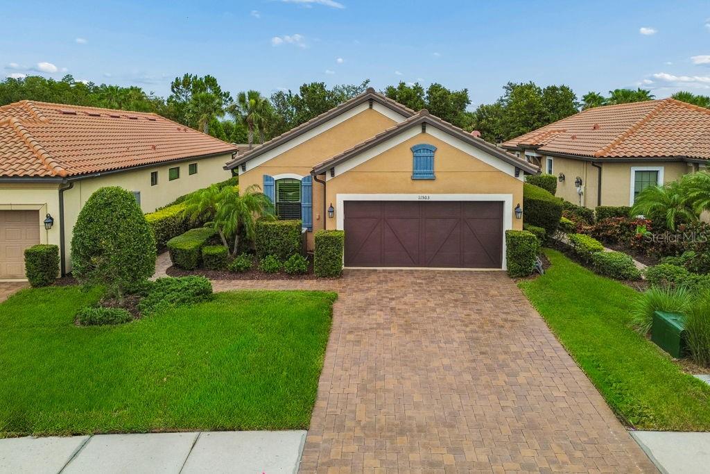 A POPULAR Taylor Morrison floor plan, the Arezzo, is ready for you in the gated community of Esplanade at Starkey Ranch. Well-known for its amenities and location, Esplanade has become a go-to for homebuyers looking for beauty, security, and tranquility. This stunning 3 bedroom, 2 bathroom, single-story residence showcases itself with a Mediterranean style exterior of stone, stucco, and corbel details. Paver driveway and walkway adds an upscale feel along with Florida native landscaping. Side entrance is captivating and private. Once inside, enjoy the open layout and tall ceilings/doors throughout. REAL wood flooring in main area, tile in prep areas and bathrooms. NO CARPET. The living area is cozy with a lot of natural light and picturesque windows and allows easy conversation to the designated dining area and kitchen. The kitchen provides a batwing island for additional seating, granite counter tops, 42in cabinets, custom backsplash, stainless steel appliances- GAS  RANGE and pantry. Dining room has crown molding/tray ceiling and can accommodate a large gathering. The primary retreat is separate and private and can easily fit a king sized bed. Beautiful windows and views of your outdoor oasis. Ensuite has dual sinks, granite counter tops, spacious walk-in tiled shower with glass enclosure and LARGE walk-in closet. Down the hall you find a flex space that can easily become a den, a fourth bedroom, an office or even a craft room- whatever your lifestyle needs! There is an upgraded bathroom with FULL tub/shower combo that provides an additional/separate entrance to the 2nd bedroom. The THIRD bedroom is tucked away towards the back of the home with added privacy. This room does provide a walk-in closet , 2 ceiling speakers, and stunning window views. Laundry room with added cabinets for more storage is right off of the 2 car garage with water softener, storage, and epoxy flooring. Tile roof. The POOL/SPA is screened in for you, is heated and is low-maintenance. Great size and perfect for the Florida life. Plenty of lanai space for lounging and entertaining and some covered space when you need a break from the sun. Mechanical systems serviced regularly. WATER SOFTENER. Callisia Dr. is a cul-de-sac street so there is minimal traffic. This home is located close to the clubhouse with kitchen and amenities which includes: heated salt-water pool, pickleball, tennis courts, fire pit area, park, dog park. In Starkey Ranch main, you also get to enjoy 3 additional pools, more parks and dog parks, Cunningham Lake, a public library, the Starkey K8 school, basketball courts, a track, tennis courts, a district park to include soccer/football/baseball fields, and MILES of walking/biking trails throughout the Starkey Ranch preserve. As an Esplanade resident, you get to enjoy maintenance free lawn care/landscaping! Grocery, medical, entertainment, restaurants, and shopping all nearby. Travel to both Tampa and Clearwater International airports are about 35 minutes away. This home has a lot, yet has room to make it your own. Click on video link for more!