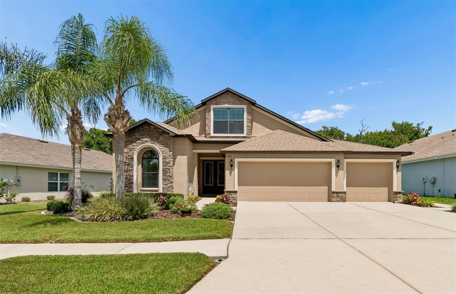 Welcome to 6601 Sparkling Way, the original builder's spec home, perfectly situated in the highly sought-after Oak Creek community. This impeccably maintained 4-bedroom, 2-bathroom home with a spacious bonus loft, 3-car garage, and just under 2,500 square feet offers an exceptional combination of quality, comfort, and privacy. Enjoy beautiful pond views from the front with no homes directly across the street, while the fully fenced backyard backs to peaceful woods with no rear neighbors.

From the moment you arrive, you'll be impressed by the lush tropical landscaping, elegant stone front accents, and grand double 8-foot frosted glass entry doors. Inside, soaring ceilings, decorative arches, decorative niches, and an open-concept floor plan create a bright and inviting atmosphere. Large double-pane windows and sliders fill the home with abundant natural light, while tile flooring throughout the main living and wet areas provides easy maintenance. The bedroom carpet looks practically brand new.

Designed for both everyday living and entertaining, the gourmet kitchen features 42-inch maple cabinetry with crown molding, granite countertops, a large center island with breakfast bar and undermount sink, stainless steel appliances, a built-in wine cooler, a spacious pantry, and a sunny breakfast nook overlooking the expansive family room area.

One of the many highlights of this home is its incredibly flexible floor plan. The current owners have customized the layout to best suit their lifestyle by utilizing the family room as their formal dining area, while the traditional living and dining rooms have been transformed into a spacious sitting and gathering area. Whether you love this unique arrangement or prefer the original design, the floor plan can easily accommodate either setup, giving the next owner the flexibility to make the home their own.

The spacious primary suite is a relaxing retreat featuring dual granite vanities, a large walk-in closet, a garden tub, and a separate glass-enclosed tiled shower. Upstairs, the oversized bonus loft offers incredible flexibility as a media room, playroom, home office, or even a potential fifth bedroom. The charming window seat overlooks the tranquil pond, creating the perfect place to relax.

One of the standout features of this home is the oversized 3-car garage, complete with its own dedicated air conditioning unit and additional recessed lighting, making it an ideal space for a workshop, home gym, hobbies, or additional entertaining space.

Step outside to the covered and screened lanai and enjoy your own private backyard oasis with peaceful wooded views and no rear neighbors.

Residents of Oak Creek enjoy outstanding community amenities including a resort-style pool, playground, basketball court, dog park, and neighborhood park with a sitting area. Conveniently located near The Shops at Wiregrass, Tampa Premium Outlets, The Grove, restaurants, hospitals, top-rated schools, and with easy access to I-75, I-275, downtown Tampa, Zephyrhills, and Dade City.

Homes this meticulously maintained rarely become available. As the original builder's spec home, it offers premium upgrades, exceptional privacy, a versatile floor plan, and a location that's hard to beat. With a low HOA and countless features throughout, 6601 Sparkling Way truly checks every box. This is one you won't want to miss!