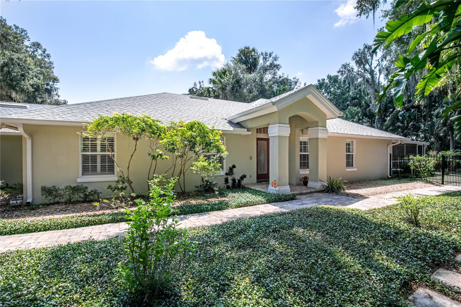 Virtually Staged. Welcome nature lovers and boat enthusiasts! This is your opportunity to enjoy living along the shores of the beautiful Harris Chain of Lakes, without the waterfront price tag! This popular community on Lake Beauclaire is situated between Mount Dora and Tavares on the south side of the Harris Chain of Lakes. By boat, you are about 20 minutes to public docks in downtown Mount Dora and 25 minutes to the seaplane base and docks in downtown Tavares. As you drive back toward Beauclaire Court, you will see that careful consideration was taken by the community to ensure that properties continue to adhere to the rural lifestyle that is appreciated back here. When you pull into your driveway, you will immediately notice the skill and care put into the landscaping. Every little detail was carefully planned and lovingly maintained. The long paver driveway offers an abundance of parking for cars, trailers, etc. There is a 3 car garage with the 3rd stall separated from the main garage. That separate stall is air conditioned and heated by the main HVAC for the home. It still has the overhead door in case you want to use it for parking and the doors are insulated to keep heat out. It could be used as a workshop, man cave, game room, craft room, library, and many other uses. Inside the home, you will find an open floorplan that is great for entertaining. The large kitchen has custom wood cabinetry, accent lighting, a built in desk, lots of pantry space, and stainless appliances. The cabinets have pull out drawers for easy access to all your kitchen gear. There is a bar area for seating and a separate breakfast nook for a casual dining space next to the kitchen. It overlooks the living room and there is also a huge family room (or would be a perfect spot for a large dining room table for big gatherings). This space is light and bright as it overlooks the pristine gardens in the back yard. There is also a large screened lanai for entertaining and dining space. A great layout for cooler days when you can open up and fill the home with fresh air! Back inside, there are 3 bedrooms and 2 full bathrooms (also with custom wood cabinetry), as well as an inside utility room and half bath just inside from the garage. The 3rd bedroom currently has French doors to make it a light and bright office but also has a closet so you can use it as a bedroom. All throughout the home, there are plantation shutters on all the windows, including shutters for the sliding doors along the back of the home. The yard is amazing with it's paver walkways (which extend 360 degrees around the property), five foot aluminum fenced in area with river rock and pea gravel, storage shed, and lush greenery everywhere. The yard backs up to a densely wooded area, allowing you to simply enjoy the sounds of nature and peace. The home is wired for an external portable home generator, however the generator is NOT included. There is a LOT of storage here and the attic has plywood flooring for a large area for additional storage. This home is move-in ready so you can start enjoying the pleasures of living in a lakefront community!