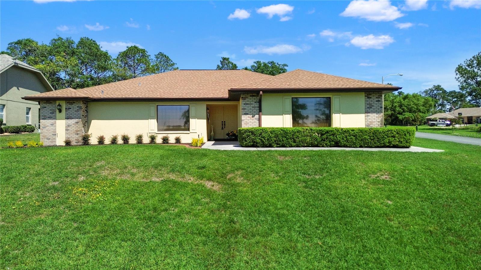 Welcome to 12001 Granada Place in the beautiful, well-kept Seville Golf Community! Pride of ownership exudes throughout this property- a one-owner concrete block, stucco home sitting high on a corner lot with pristine landscaping, a 2023 ROOF, and a fantastic floor plan for easy living! Step into the foyer on meticulously-kept tile floors, an open-concept living and dining room to your left. Natural light pours into the large windows which are perfectly framed with custom window treatments. The living room is open and airy, and the eat-in kitchen with barstools, plus a second breakfast table make your dining experience both joyful and functional. The primary bedroom suite sits on one end of your home, can easily fit a King-sized bed, plus more furniture, and offers a large en-suite bath with deep soaker tub and a step-in shower with tile, plus double sinks. Two closets including a large walk-in closet found here. Just off of the primary bedroom is a sewing/ craft/ office room with window and closet for your hobbies. This would make a great nursery or library too. On the other side of this split floor plan home, there are two more bedrooms and another full bathroom with tub/ shower combo. Don't miss the indoor laundry with washer/ dryer to convey, plus more storage cabinets, on your way to the 22.6x20 ft. garage. This property is completely move-in ready: ROOF (2023); Exterior Repaint (2025); 3.5 ton HVAC w/ heat pump (2019); AO Smith Electric Hot Water Heater; Resealed Patio Lanai with rock surface; Pristine Landscaping & Irrigation System. Public water & sewer. Located just off of US-19 & US-98, don't miss your chance at getting into this lovely neighborhood of well-kept, custom-built homes. What a gorgeous place to call HOME!