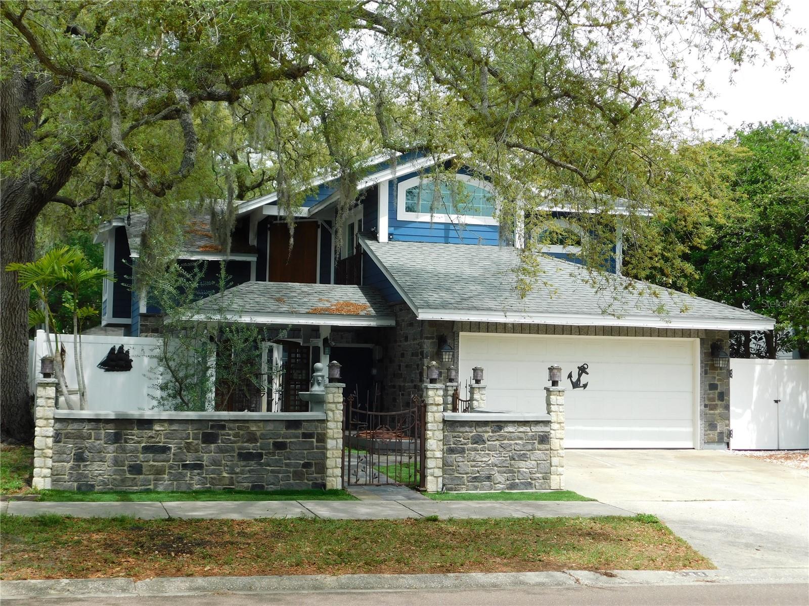 Here is your chance to own Safety Harbor's famous Pirate House! This unique home is located in the heart of Safety Harbor....just a short distance to Phillippe Park, Tampa Bay, schools, and downtown. The owners spared no expense when redoing the exterior of this custom home. From upgrading the siding to installing hurricane rated windows and doors. They also added a double courtyard entrance with a stone wall facade and custom wrought iron gates. Beautiful French doors lead you into a vaulted foyer that is wrapped by a staircase. Ample kitchen with granite counters, stainless steel appliances, a breakfast room with bar and built-ins. There is also a dining area off the kitchen, which leads you outside, through another set of French doors. Spacious Living room is great for entertaining...there is even a spot for an aquarium. In the hall, there is a built in cubby for your little furry friend. Travertine tiles run throughout the first floor. Upstairs...there are 3 spacious bedrooms. The primary has Vaulted ceilings, a walk in closet, a French door opening to a Juliet balcony, a private bathroom with a double vanity, double jetted tub, and skylight. The 2nd bedroom is oversized with a hidden Murphy bed, vaulted ceilings,  pocket door access to the hall bath, and a French door leading out to a balcony that overlooks the backyard. The 3rd bedroom has a custom wall grid system, vaulted ceilings, a French door leading to a balcony and would make a great room to display collections, hobbies, or run a home based business. The hall bath features a walk in shower with a one of a kind, etched glass enclosure. Out back, this home has an expansive patio area with slate tile, a hot tub, no maintenance lawn, and a treehouse!  The treehouse was built in a way that allows the tree to continue to grow. It has a lookout spot on the roof and a ramp so your furry friend can come visit. Don't miss out on this unique opportunity to live your dream in the coolest house in town!