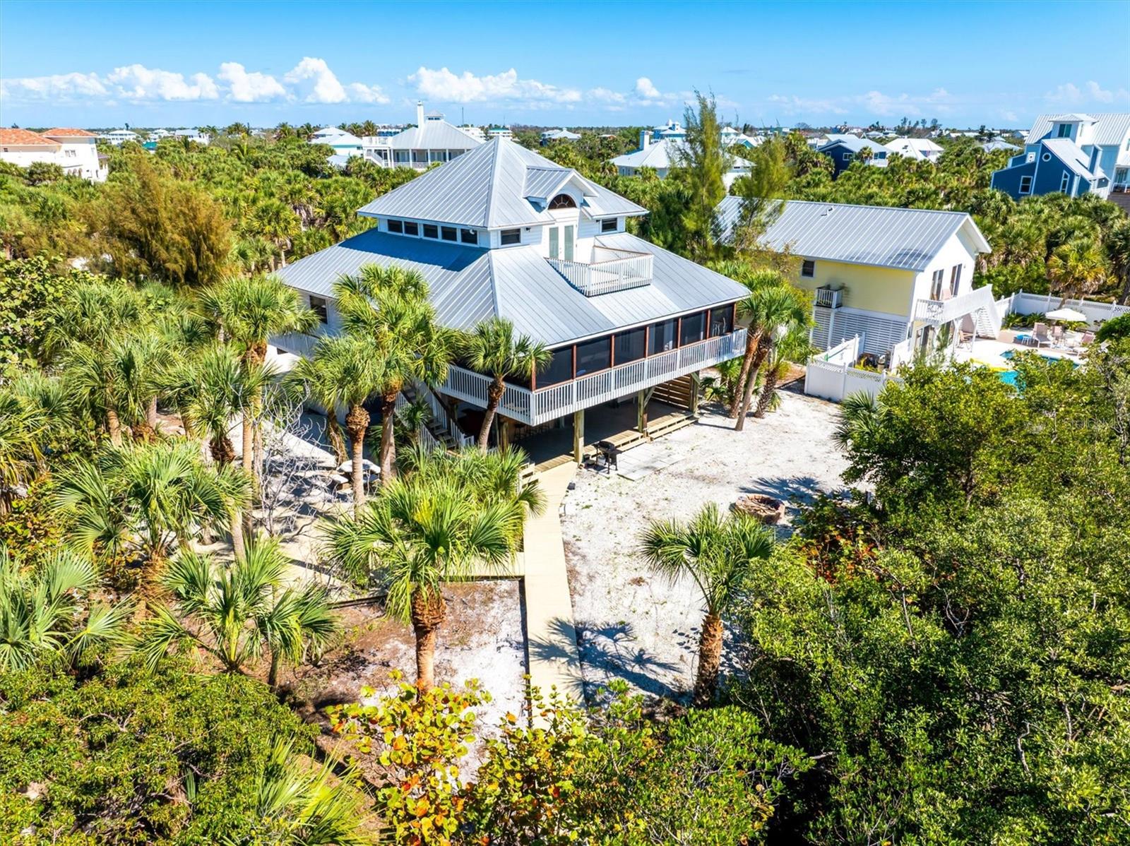 Welcome to 51 Palm Drive located on beautiful Palm Island, Florida. This waterfront island home offers the ultimate in coastal living, combining direct Gulf access, stunning sunset views, and the privacy of a barrier island lifestyle with over seven miles of pristine sandy beaches just moments away.

Situated on an oversized corner lot, this 3-bedroom, 2-bath residence features a private dock on a saltwater canal with no bridges to the Gulf of Mexico—a true boater’s dream. Enjoy effortless days on the water with quick access to world-class fishing, boating, and island hopping.

Inside, the home showcases an open-concept floor plan designed for relaxed coastal living, with a spacious great room, beautiful Spanish tile and wood flooring, and warm knotty pine walls and ceilings that create a classic island feel. The remodeled kitchen is both stylish and functional, featuring granite countertops, stainless steel energy-efficient appliances, under-cabinet lighting, wine rack, and a granite topped kitchen island perfect for entertaining.

Wake up to Gulf views and breathtaking sunsets from the top-floor primary suite, complete with a beautifully updated travertine bathroom, dual vanities, garden tub and a rain shower. Outdoor living is just as inviting with a screened second-floor porch, fire pit, a charming hexagon deck nestled among mature palms, and lush Florida-friendly landscaping.

Additional features include a metal roof with radiant barrier, 15 SEER Trane A/C system with UV light and connection to public water and cable—offering comfort, efficiency, and peace of mind.

With ample room to add a pool and positioned as one of the best values for a 3-bedroom waterfront home with direct Gulf access on Palm Island, this property is ideal as a full-time residence, vacation home, or investment opportunity.

Experience the beauty of Palm Island living—where nature, tranquility, and coastal luxury come together.