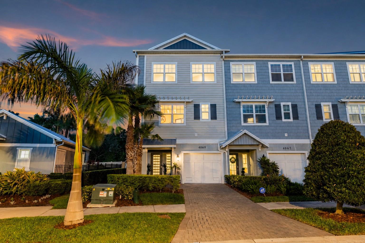 Experience elevated, maintenance-free living in this beautifully appointed end-unit townhome located within the highly desirable gated community of The Cove at Rocky Point. Designed with both elegance and functionality in mind, this three-story residence features a private elevator, 3 spacious bedrooms, a potential 4th bedroom/ office, 3 full bathrooms, and exceptional finishes throughout, creating the perfect blend of luxury and everyday comfort. A welcoming foyer greets you upon entry and provides convenient access to the private elevator and oversized tandem 2-car garage, offering generous space for vehicles, storage, bicycles, or recreational equipment. Every level of this thoughtfully designed home has been crafted to maximize space, natural light, and effortless living. The second floor serves as the heart of the home, showcasing an expansive open-concept design ideal for entertaining. The spacious living and dining areas flow seamlessly into the designer kitchen, where culinary enthusiasts will appreciate premium GE Café stainless steel appliances, an Electrolux induction cooktop, elegant quartz countertops, custom cabinetry, a stylish tile backsplash, and a generous closet pantry. A built-in coffee system within the refrigerator adds an extra touch of convenience for your morning routine. This level also includes a versatile office or flex room, a full bathroom, and a private covered balcony overlooking the beautifully landscaped community and sparkling resort-style pool. The upper level is dedicated to rest and relaxation. The luxurious primary suite offers a peaceful retreat complete with a comfortable sitting area, abundant closet space, and a spa-inspired ensuite featuring upscale finishes designed for everyday indulgence. The primary bathroom features a steam shower. Two additional guest bedrooms provide generous accommodations, while a full guest bath and conveniently located laundry room equipped with an Asko washer and dryer complete the third floor. Numerous upgrades enhance the home's appeal, including impact-rated windows and doors, elegant crown molding, EV Charger, custom window treatments, designer lighting, and high-quality finishes throughout. Every detail reflects pride of ownership and modern craftsmanship. Residents of The Cove at Rocky Point enjoy an exceptional lifestyle with maintenance-free living and outstanding community amenities. Relax by the resort-style swimming pool, enjoy the beautifully maintained grounds, or launch a kayak or paddle board from the community observation dock, offering direct access to the scenic waterways leading into Tampa Bay. Ideally situated just minutes from Tampa International Airport, Berkeley Preparatory School, International Plaza, Rocky Point Golf Course, downtown Tampa, major business districts, fine dining, shopping, and entertainment, this location provides unmatched convenience while maintaining a peaceful residential setting. Providing luxurious finishes, an exceptional floor plan, premium upgrades, and one of Tampa's most convenient locations, this remarkable townhome presents an outstanding opportunity to enjoy Florida living in an exclusive waterfront community.
