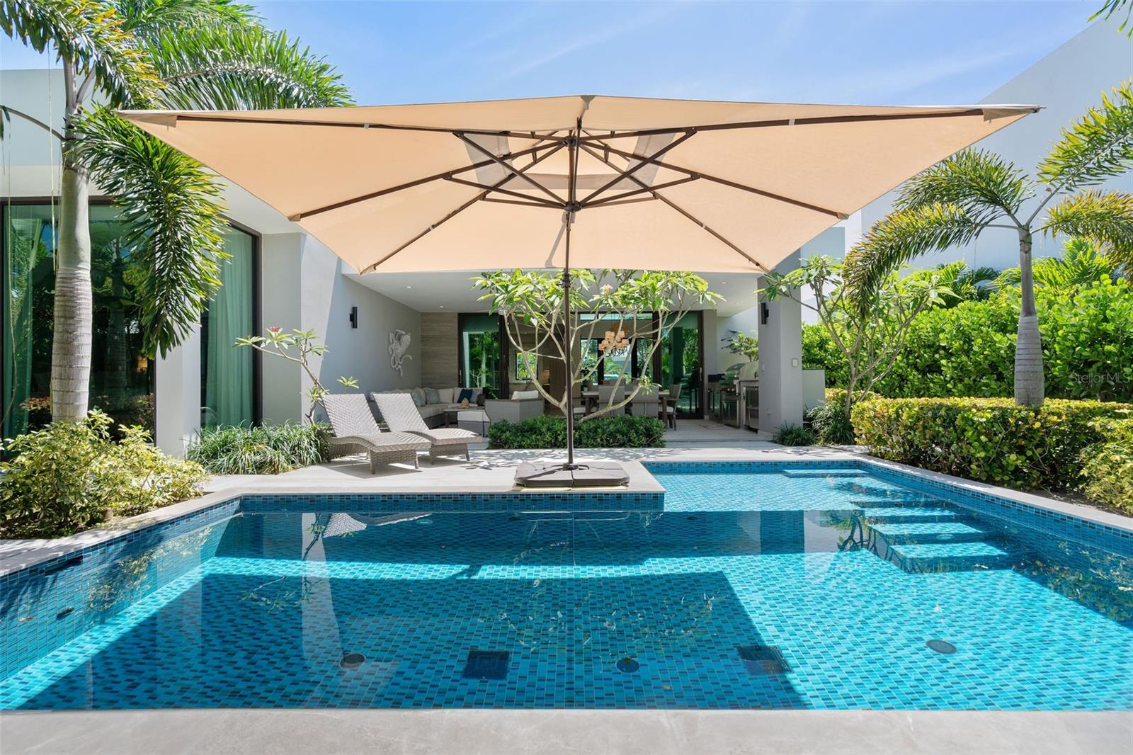 This beautifully curated one-story residence is a private tropical retreat, set on an 883-square-meter lot with approximately 3,550 square feet of gross construction and 2,500 square feet of conditioned living space in the The Isles, a community within the Dorado Beach Resort and Club. From the moment you arrive, the home feels like a beach sanctuary where mature landscaping surrounds the property, creating a sense of privacy and tranquility that feels both natural and established. Designed for seamless indoor-outdoor living, the residence opens to a resort-style outdoor area featuring a private pool, covered terrace, outdoor shower, and built-in BBQ kitchen space including a Wolf Grill, perfect for entertaining or relaxed island living. A double-car garage plus a separate golf cart garage adds convenience and functionality to take you within the 2,700 acre resort. Inside, the home reflects a refined yet relaxed beach aesthetic, thoughtfully curated with designer wallpaper, elegant lighting fixtures, and elevated finishes throughout. The interior design vision, guided by renowned Puerto Rico designer Caro Banazar, brings cohesion and warmth to every space, striking the perfect balance between sophistication and coastal comfort. The kitchen is both beautiful and highly functional, featuring marble backsplash detailing, a gas cooktop for the serious chef, and premium Thermador appliances. Altogether, this residence blends tropical serenity with intentional design, offering a home that feels private and polished.