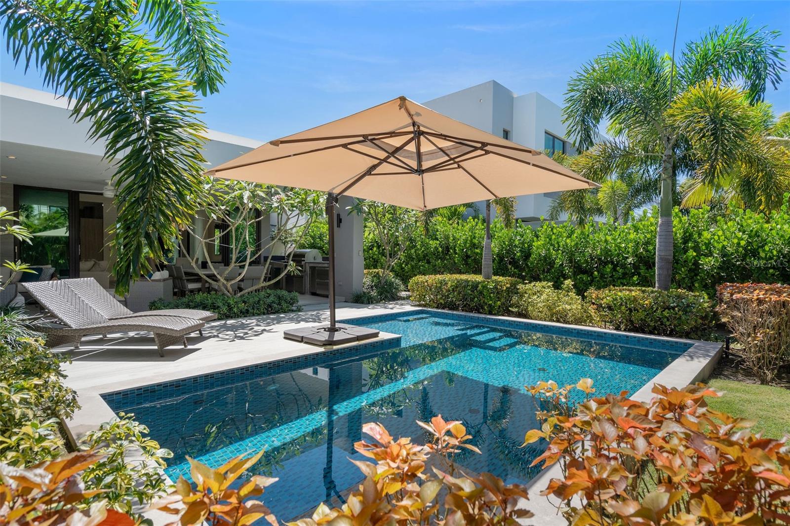 This beautifully curated one-story residence is a private tropical retreat, set on an 883-square-meter lot with approximately 3,550 square feet of gross construction and 2,500 square feet of conditioned living space in the The Isles, a community within the Dorado Beach Resort and Club. From the moment you arrive, the home feels like a beach sanctuary where mature landscaping surrounds the property, creating a sense of privacy and tranquility that feels both natural and established. Designed for seamless indoor-outdoor living, the residence opens to a resort-style outdoor area featuring a private pool, covered terrace, outdoor shower, and built-in BBQ kitchen space including a Wolf Grill, perfect for entertaining or relaxed island living. A double-car garage plus a separate golf cart garage adds convenience and functionality to take you within the 2,700 acre resort. Inside, the home reflects a refined yet relaxed beach aesthetic, thoughtfully curated with designer wallpaper, elegant lighting fixtures, and elevated finishes throughout. The interior design vision, guided by renowned Puerto Rico designer Caro Banazar, brings cohesion and warmth to every space, striking the perfect balance between sophistication and coastal comfort. The kitchen is both beautiful and highly functional, featuring marble backsplash detailing, a gas cooktop for the serious chef, and premium Thermador appliances. Altogether, this residence blends tropical serenity with intentional design, offering a home that feels private and polished.